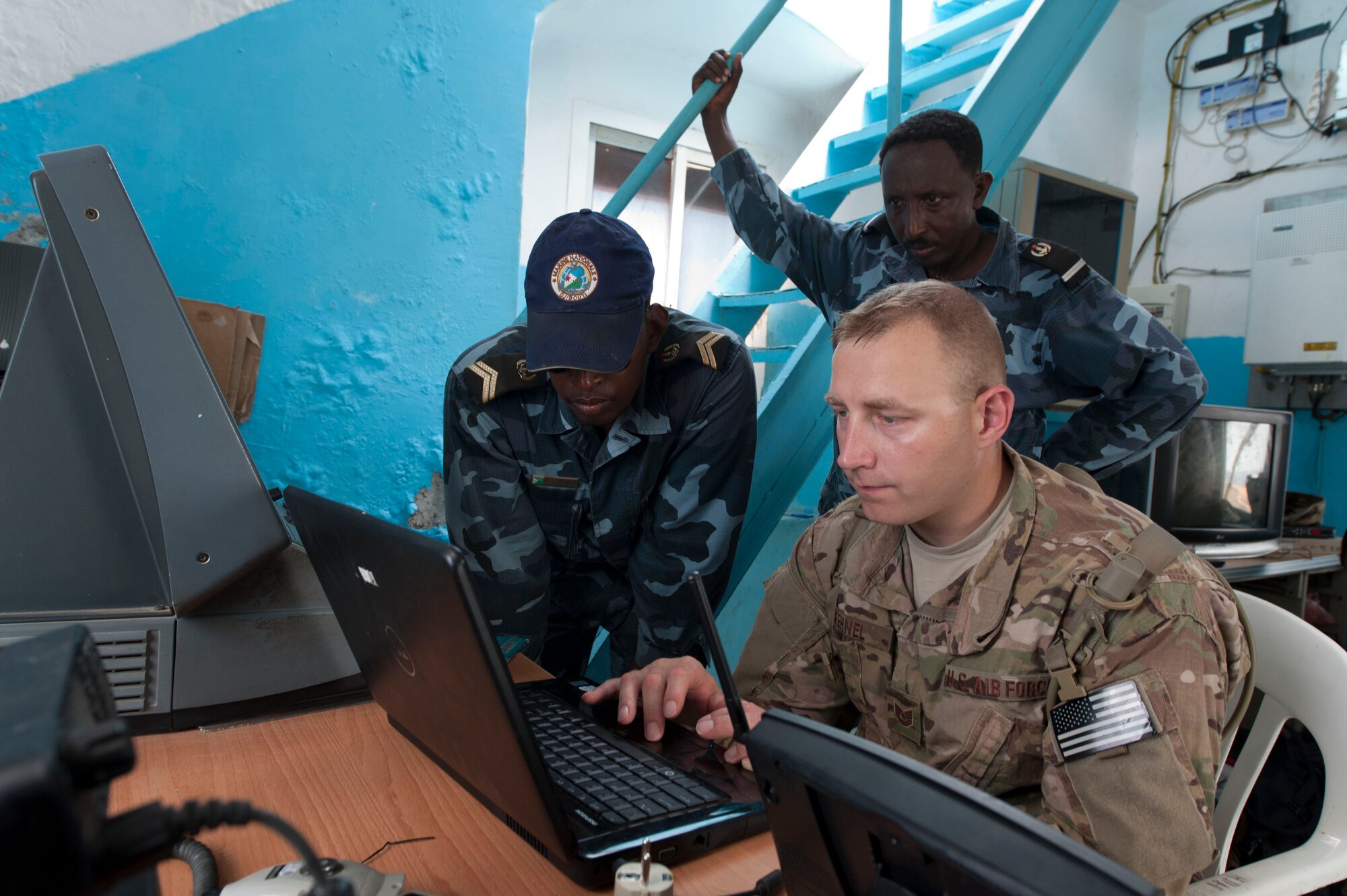 MASKALI ISLAND, Djibouti -- U.S. Air Force Tech. Sgt. Mikki Fehnel, Combined Joint Task Force-Horn of Africa (CJTF-HOA) communications maintenance technician and who is deployed from the 55th Communications Squadron at Offutt Air Force Base, Neb., right, and Djiboutian Navy Petty Officer Abdoulkader-Isse, left, install a weather-sensor program on a laptop May  1, 2014. The program supports weather sensors installed by the CJTF-HOA Meteorological and Atmospheric Operations Center, Djiboutian Navy and U.S. Africa Command weather systems support cadre.