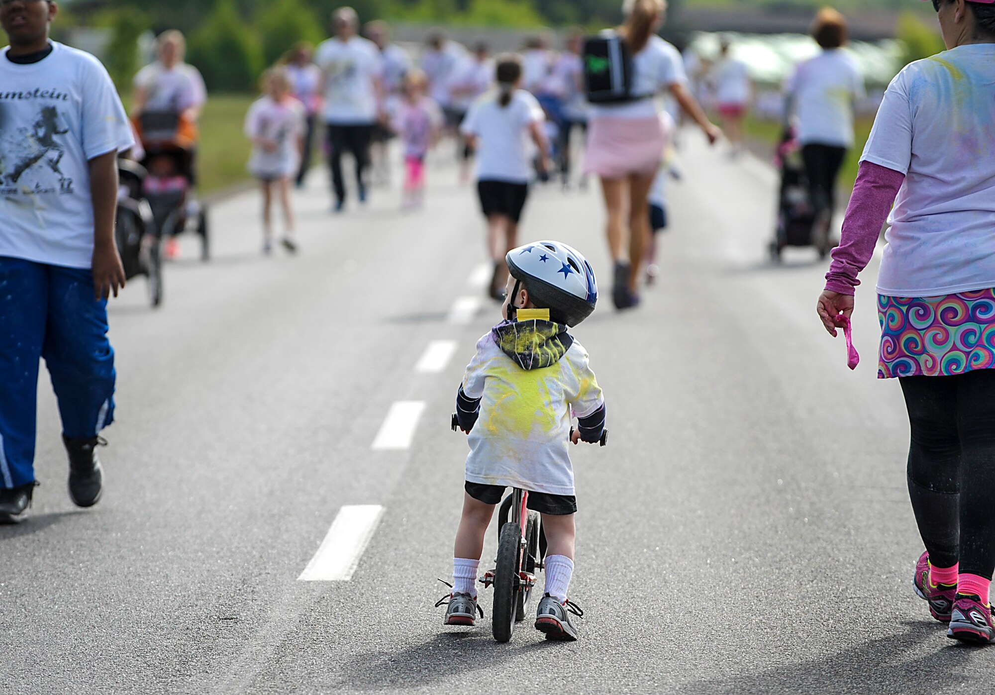 A little boy rides his bike during the Keystone Color Run on Ramstein Air Base, Germany, May 10, 2014. More than 800 participants came out for the family 5K to raise awareness for teen suicide. Proceeds were donated to a program dedicated to providing support for youth and veterans experiencing risk factors for suicide. (U.S. Air Force photo/Staff Sgt. Sara Keller) 