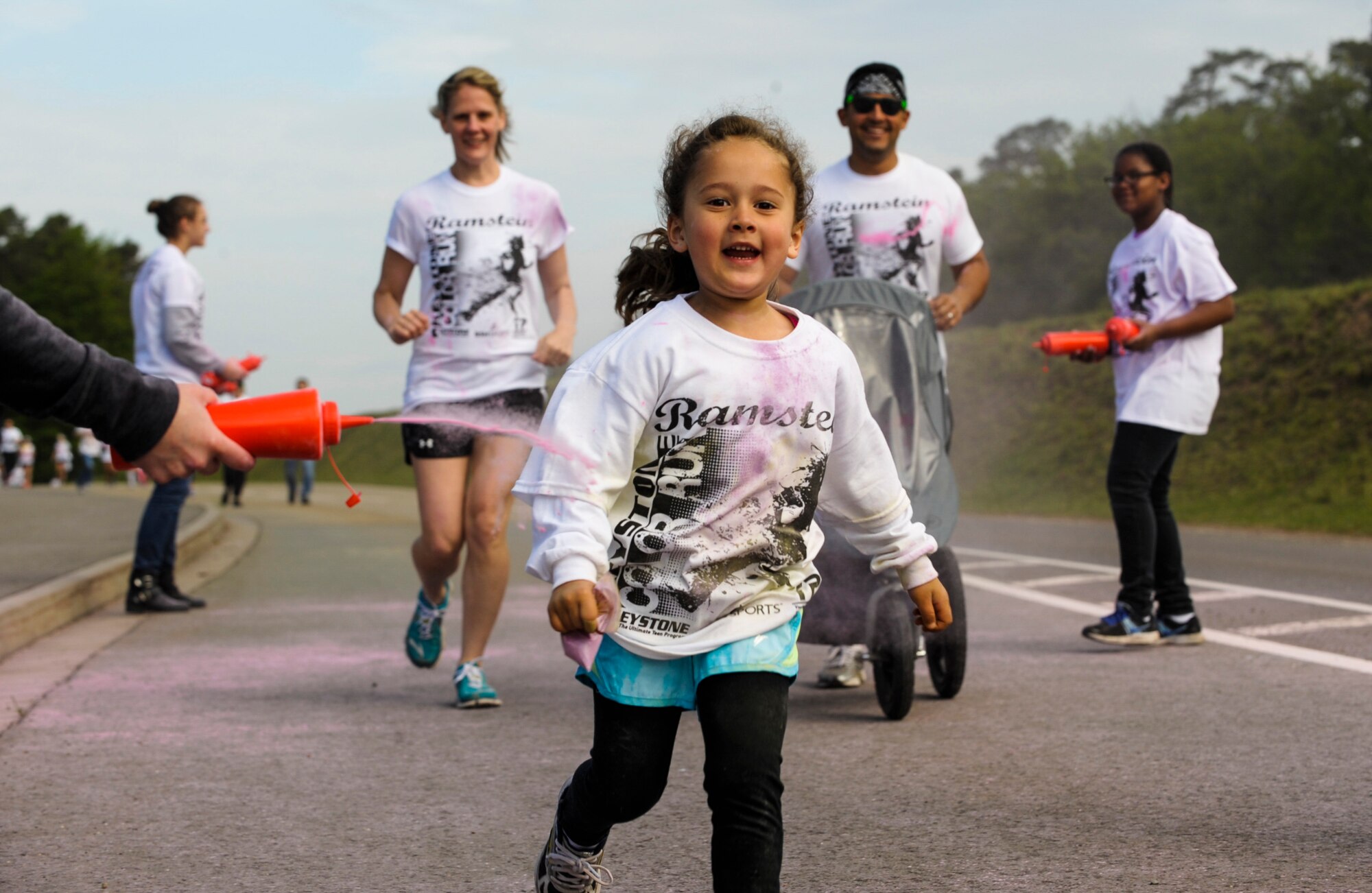 A family from Team Ramstein runs during the Keystone Color Run on Ramstein Air Base, Germany, May 10, 2014. More than 800 participants came out for the family 5K to raise awareness for teen suicide. Proceeds were donated to a program dedicated to providing support for youth and veterans experiencing risk factors for suicide. (U.S. Air Force photo/Staff Sgt. Sara Keller)