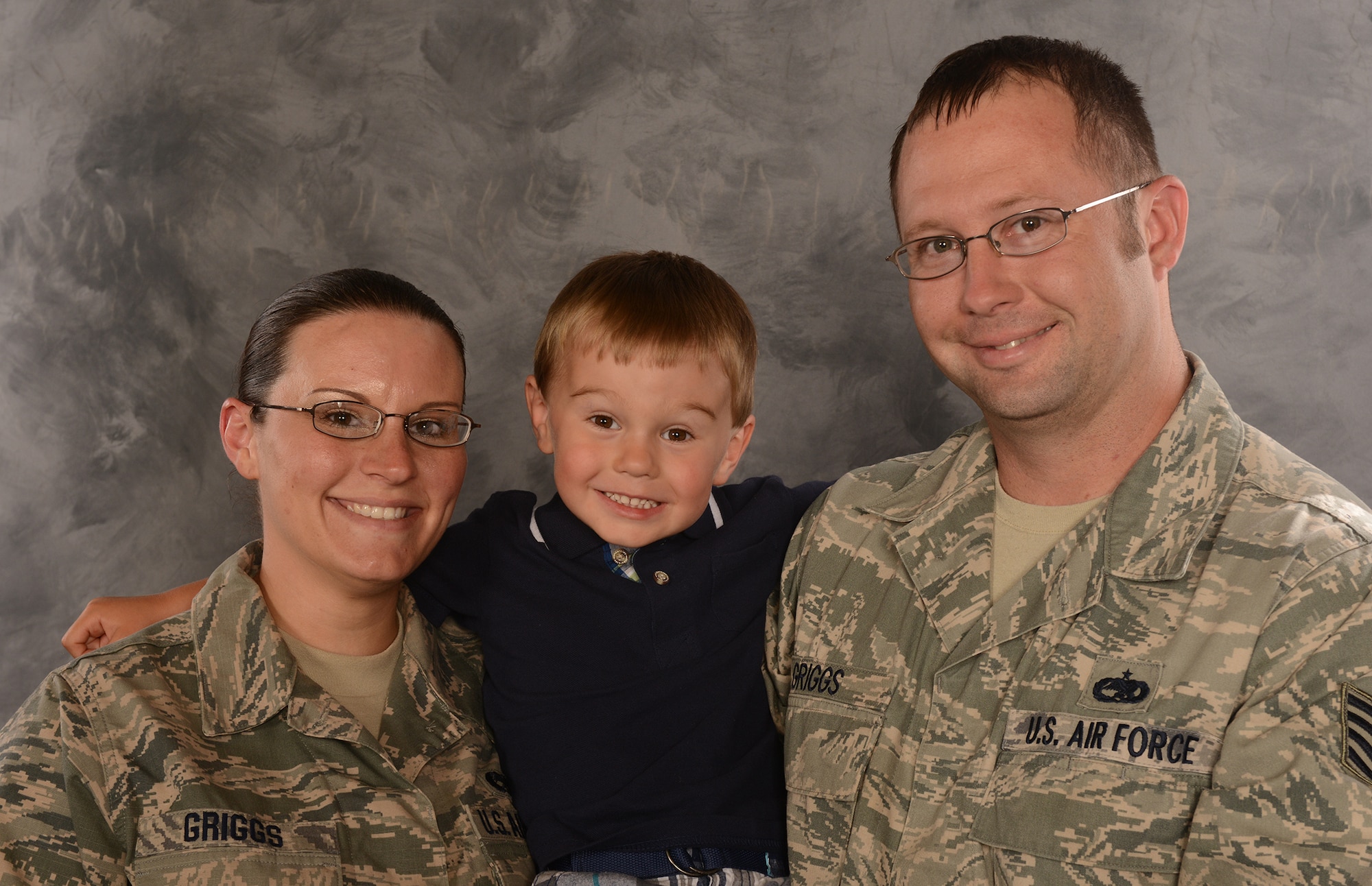 U.S. Air Force Staff Sgts. Amanda and Michael Griggs, 23d Component Maintenance Squadron aerospace propulsion craftsmen, hold their son, Korbin, for a photo at Moody Air Force Base, Ga., May 8, 2014. Amanda Griggs was deployed for 6 months of Korbin’s life to Bagram Air Field, Afghanistan and is currently 24 weeks pregnant with her second son. (U.S. Air Force photo illustration by Senior Airman Tiffany M. Grigg/Released)