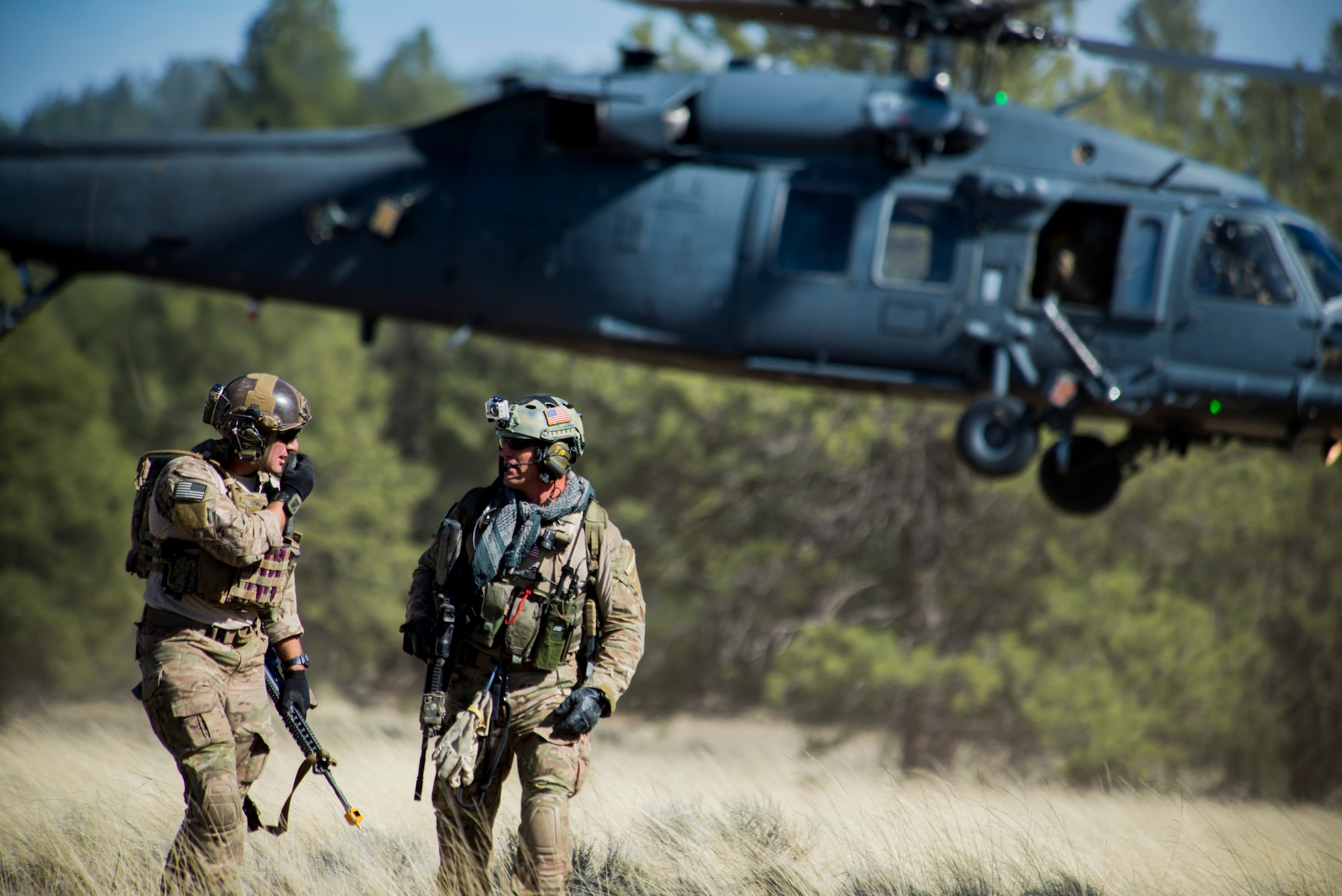 Pararescuemen from the 58th Rescue Squadron out of Nellis Air Force Base, Nev., make their way from a landing zone after being dropped off by 41st Rescue Squadron HH-60G Pave Hawk out of Moody Air Force Base, Ga., during an Angel Thunder mass-casualty exercise May 9, 2014, at Camp Navajo, Ariz. Though stationed at Nellis, the 58th RQS is a geographically-separated unit of the 23d Wing at Moody Air Force Base, Ga. (U.S. Air Force photo by Staff Sgt. Jamal D. Sutter/Released) 
