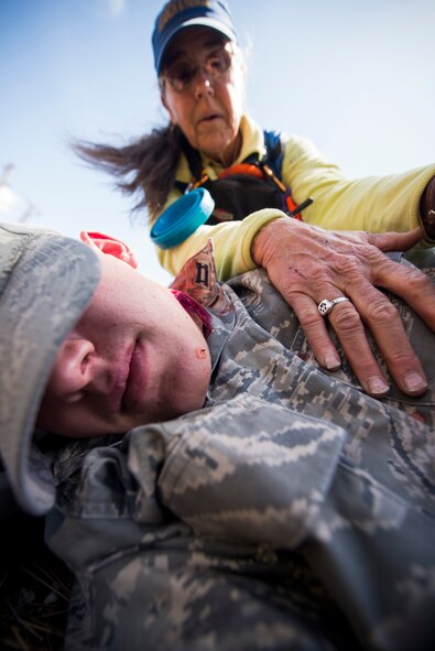 Mindy Miller, Coconino County Sheriff’s Search and Rescue Unit, assesses the condition of an Air Force ROTC cadet during an Angel Thunder mass-casualty exercise May 9, 2014, at Camp Navajo, Ariz.  Miller and her team tended to injured victims until Airmen from the 58th Rescue Squadron arrived on scene. (U.S. Air Force photo by Staff Sgt. Jamal D. Sutter/Released)
