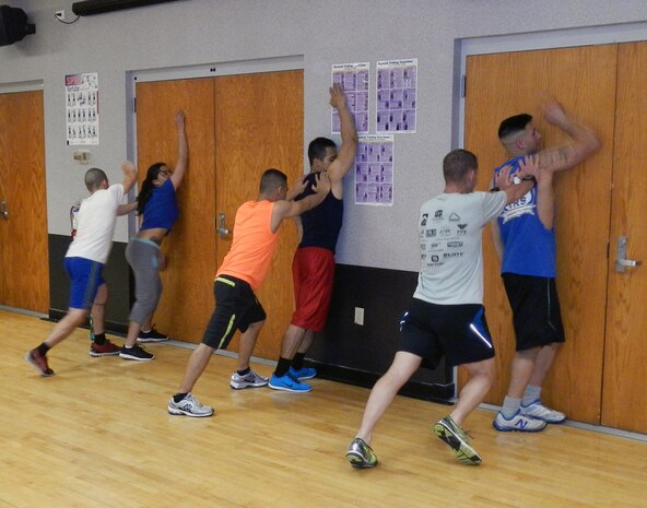 Participants practice getting away from an attacker when pinned to a wall during a Krav Maga class May 9, 2014 at the  Joint Base Charleston Air Base Fitness and Sports Center.  The classes are offered every Friday from noon till 1 p.m. through Sept. 26 as part of the Single Airman Initiative. SAI activities are primarily geared toward single Sailors and Airmen, ages 18-25, but all are welcome. (U.S. Air Force photo/Jessica Donnelly)