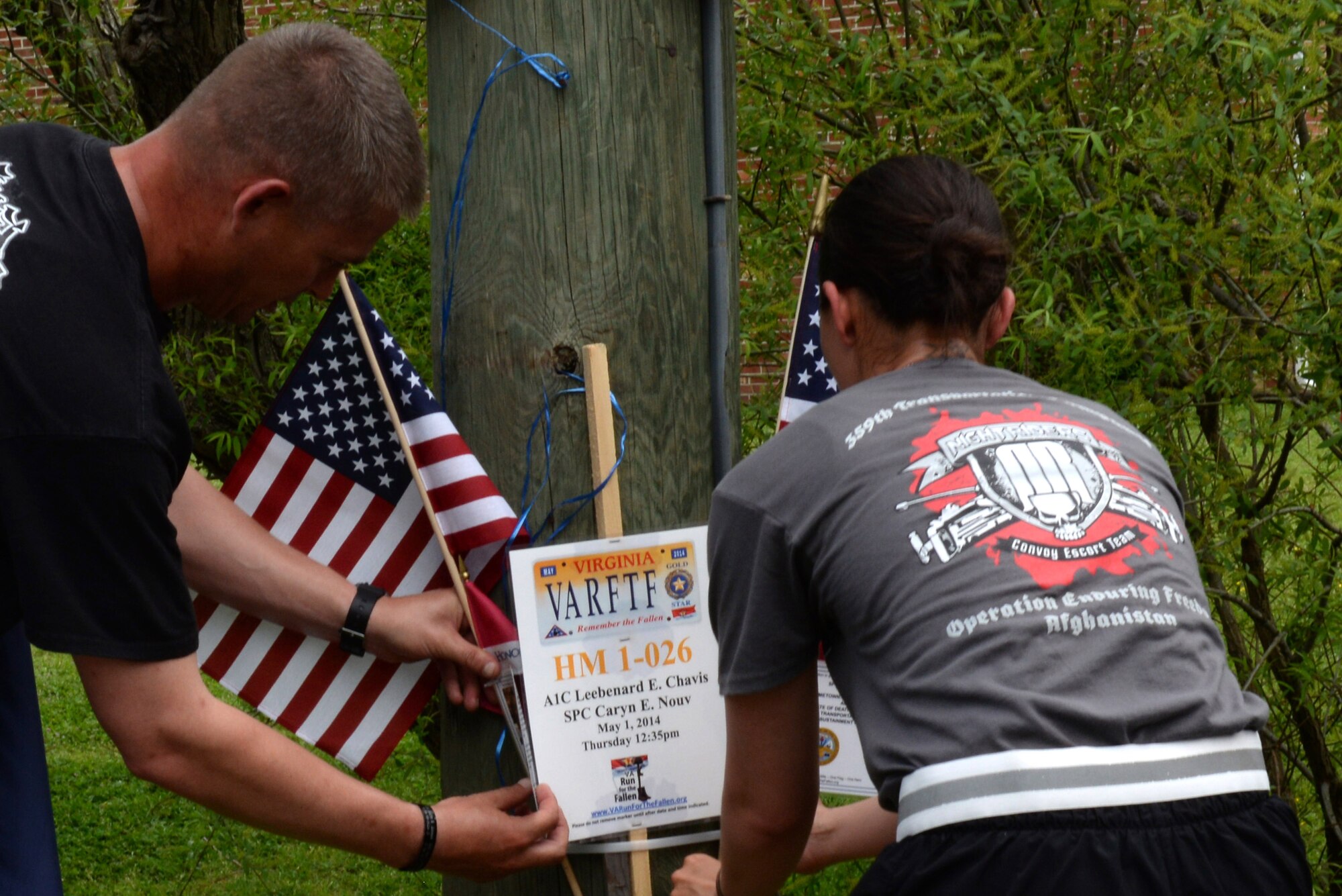 U.S. Army Soldiers from the 359th Inland Cargo Transfer Company, 10th Transportation Battalion, 7th Transportation Brigade (Expeditionary), place American flags in honor of fallen U.S. Service members during the Second Annual Run for the Fallen event in Hampton, Va., May 1, 2014. Before planting the flag, a runner read of the name, birthplace and date the respective Service member paid the ultimate sacrifice. (U.S. Air Force photo by Senior Airman Teresa J.C. Aber/Released)