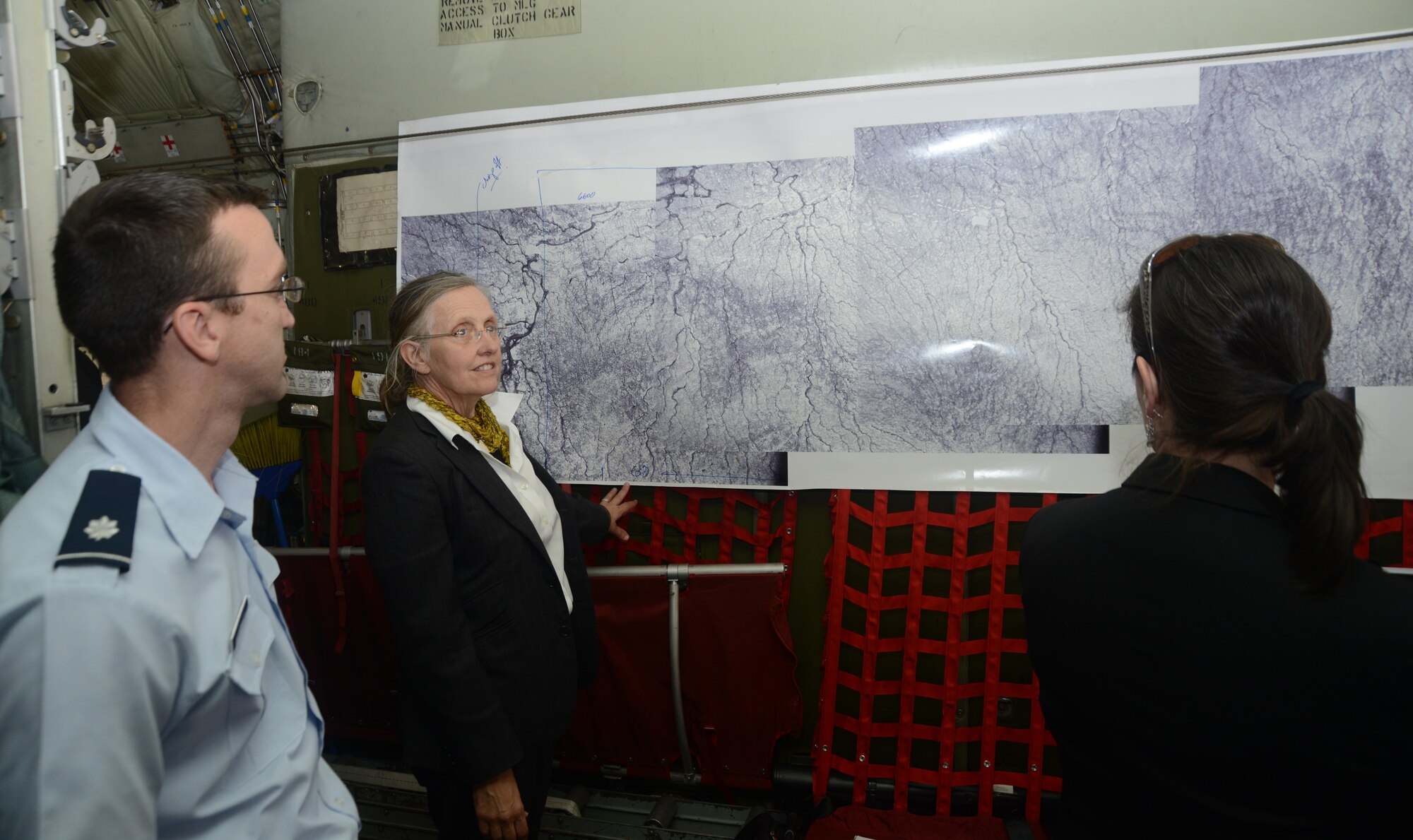Dr. Robin Bell, a scientist with Columbia University, gives visitors to a New York Air National Guard's ski-equipped LC-130 Hercules an overview of the National Science Foundation's Icepod. The pod will allow the Guard to collect research data while it conducts supply and transportation flights throughout Antarctica. (U.S. Air National Guard photo by Senior Airman John Hillier/Released)