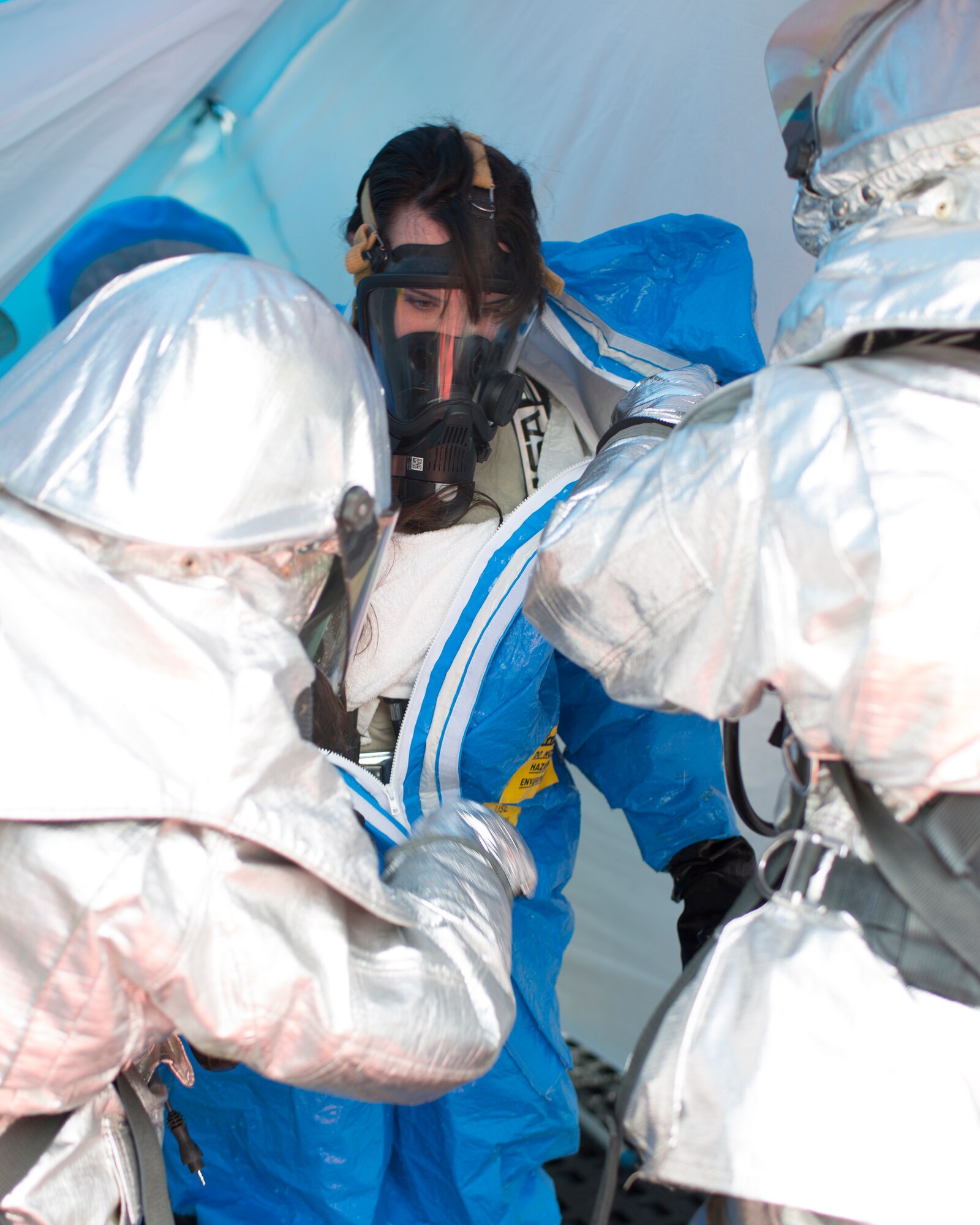 Members of a response team assist a teammate in decontaminating and removing gear during an exercise at Yokota Air Base, Japan, May 12, 2014. The team responded to a simulated chlorine gas leak, testing the speed and decision making of base support organizations during real-world emergencies. (U.S. Air Force photo by Osakabe Yasuo/Released)
