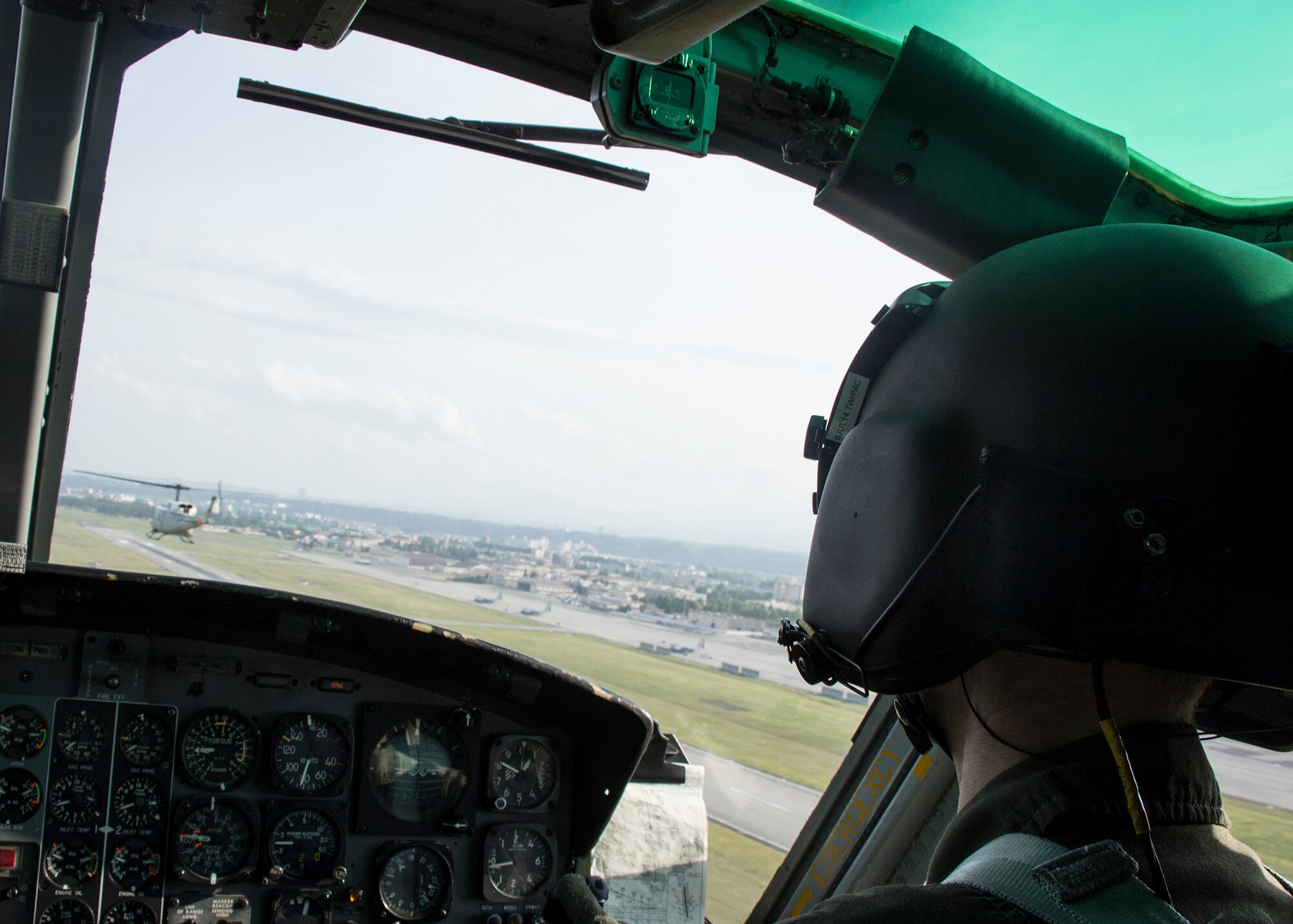Acting aircraft commander Capt. Stephen Jones, 459th Airlift Squadron, observes a UH-1N Huey flying in formation during a training sortie May 8, 2014. Yokota Airmen regularly perform practice missions to be prepared to respond to any contingency.  (U.S Air Force photo by 2nd Lt. Ashley Wright/Released)