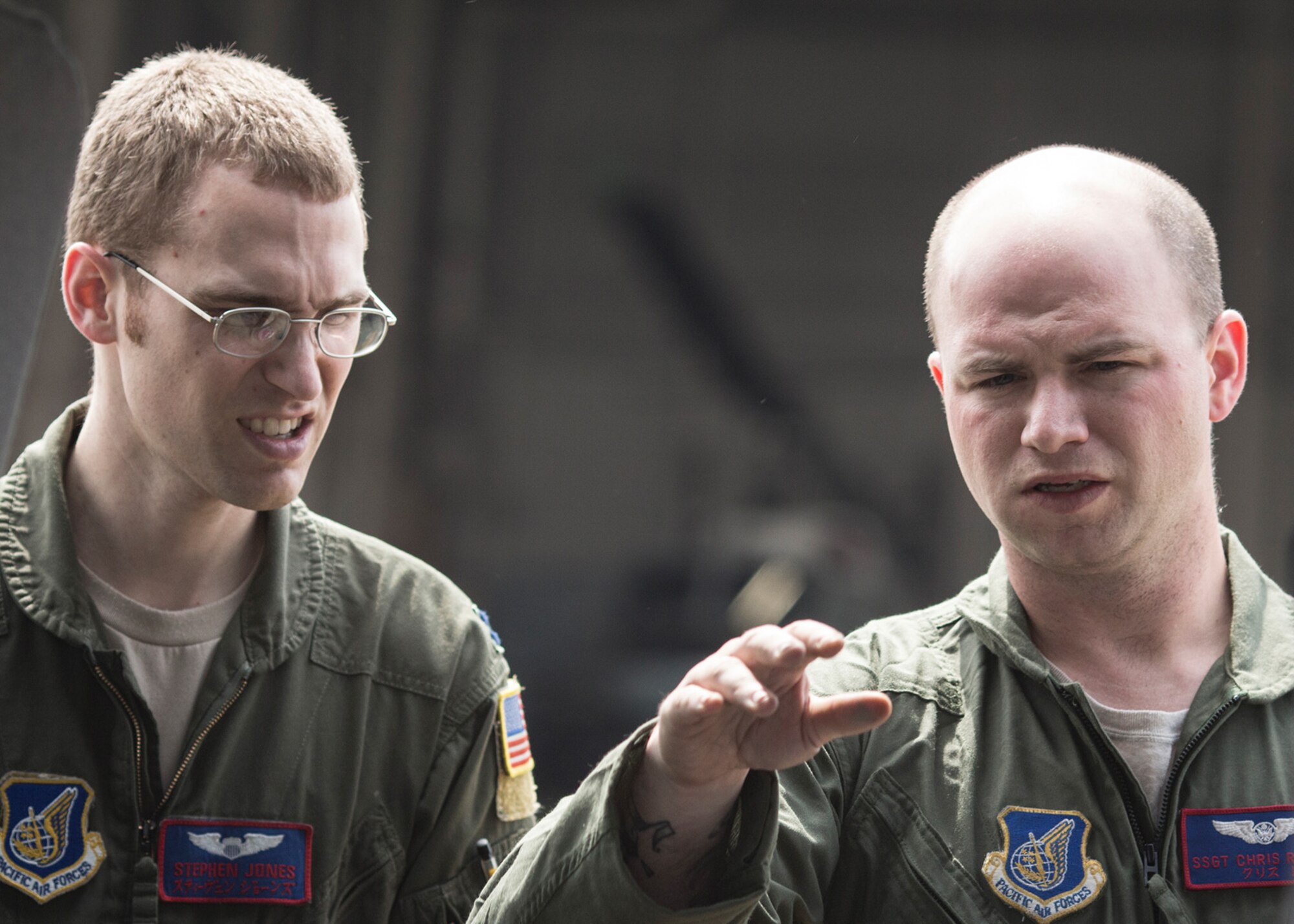 Staff Sgt. Chris Rector, 459th Airlift Squadron flight engineer, speaks with acting aircraft commander Capt. Stephen Jones about a pre-flight checklist item, May 8, 2014. The 459th performed UH-N1 Huey small formation training sorties on May 8 and 9 to improve interoperability. (U.S Air Force photo by 2nd Lt. Ashley Wright/Released)