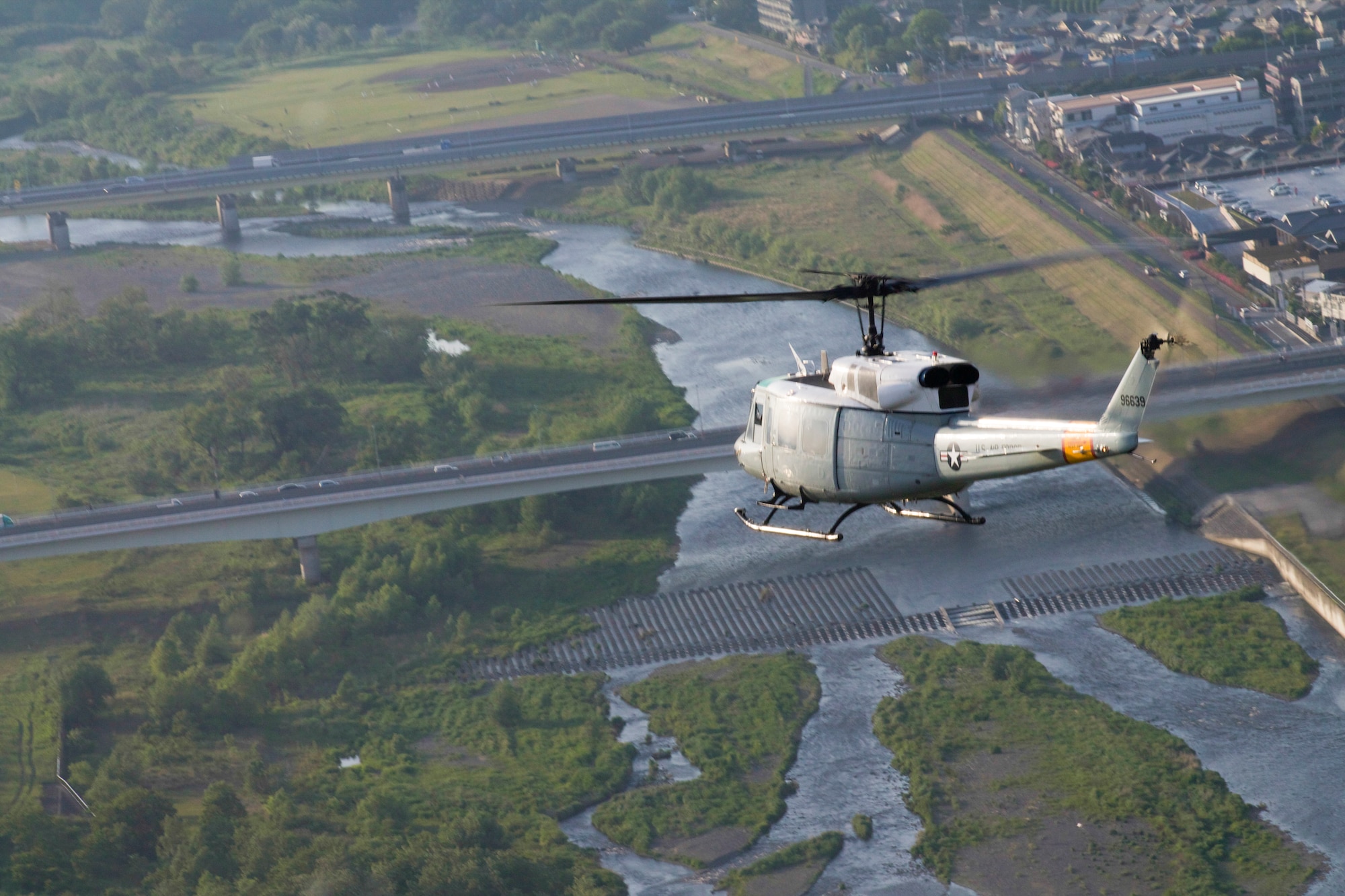 Members from the 459th Airlift Squadron fly UH-1N Huey helicopters along the Tama River in Japan, May 8, 2014. Regular training allows the pilots to provide aeromedical evacuation and humanitarian disaster relief capabilities in the event of an emergency. (U.S. Air Force photo by Airman 1st Class David Danford/Released)