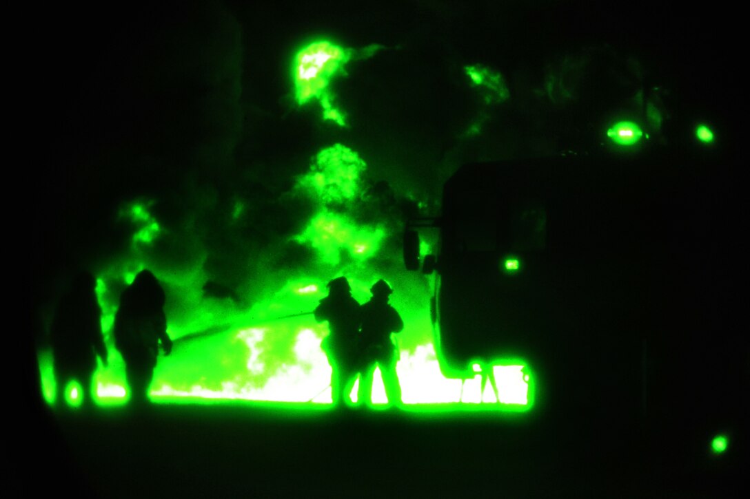 As seen through a night-vision device, Air Force firefighters suppress a controlled fire during Exercise Patriot Warrior on Fort McCoy, Wis., May 4, 2014.