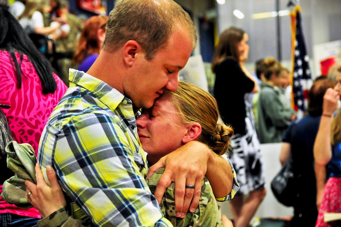 Army Spc. Jessie Nelson hugs her husband, Matt, on Joint Base Lewis-McChord, Wash., July 10, 2013. Nelson and about 230 soldiers returned home after an eight-month deployment to Afghanistan to support Operation Enduring Freedom. Nelson is an all-source intelligence analyst assigned to the 2nd Infantry Division's Headquarters Company, 4th Stryker Brigade Combat Team.  
