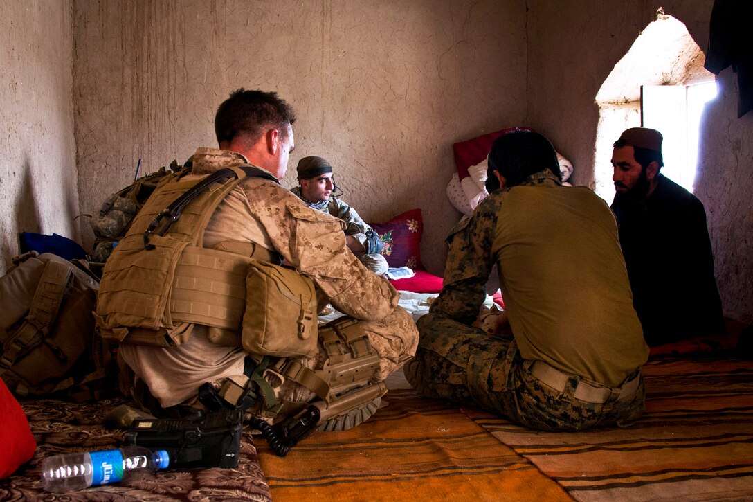 U.S. Marine Corps 1st Lt. Stephen T. Desmond, left, and Georgian soldiers talk with Afghan villagers during Operation Northern Lion in Mohammad Abad village in Helmand province, Afghanistan, June 24, 2013. Desmond is assigned to Georgian Liaison Team 9.  
