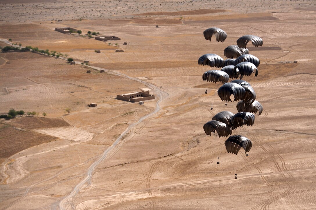 Pallets descend to the ground after being air dropped from a C-17A Globemaster III aircraft over the outskirts of Ghorak village in Afghanistan’s Kandahar province, June 27, 2013.  
