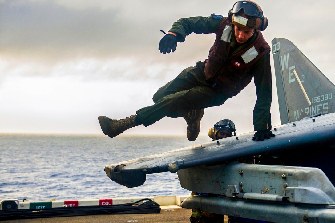 U.S. Marine Corps Cpl. Ben Hudson climbs off the wing of an AV-8B Harrier jet aircraft after moving it aboard the amphibious assault ship USS Bonhomme Richard in the East China Sea, June 26, 2013. The Richard is conducting routine joint operations in the U.S. 7th Fleet area of responsibility. Hudson is assigned to the 31st Marine Expeditionary Unit.  
