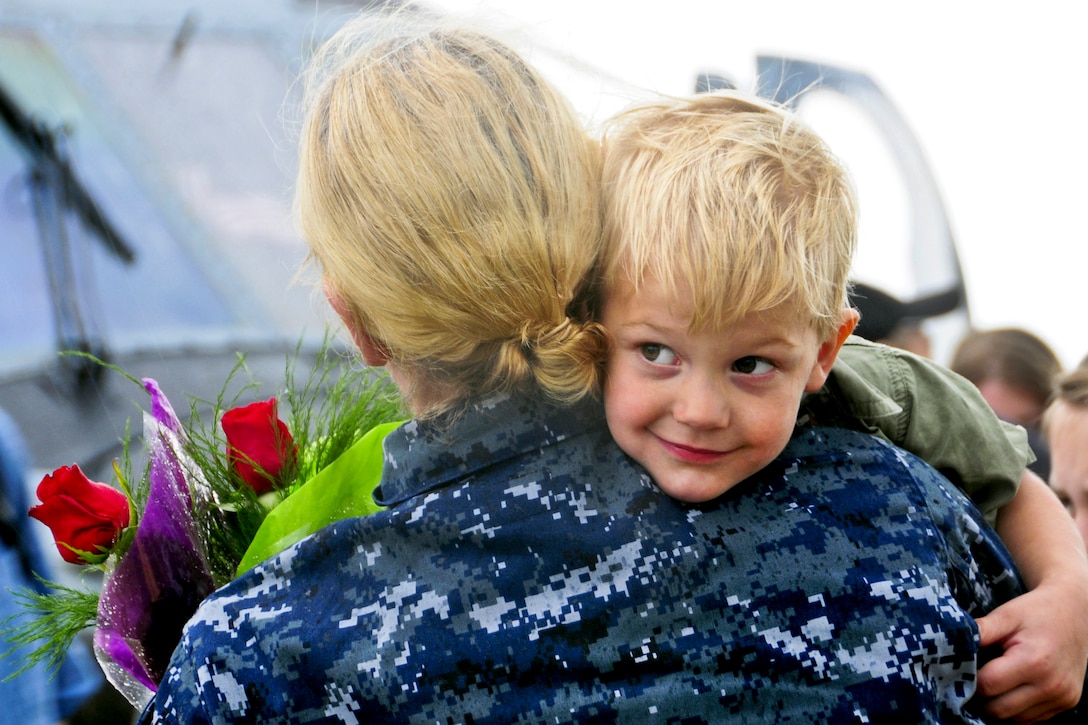 A sailor gets a homecoming hug from a boy during a celebration for the Dwight D. Eisenhower Carrier Strike Group at its homeport in Norfolk, Va., July 2, 2013. The carrier group is returning to its homeport after operating in areas of responsibility for the U.S. 5th and 6th fleets. The sailors are assigned to Helicopter Anti-submarine Squadron 5.  
