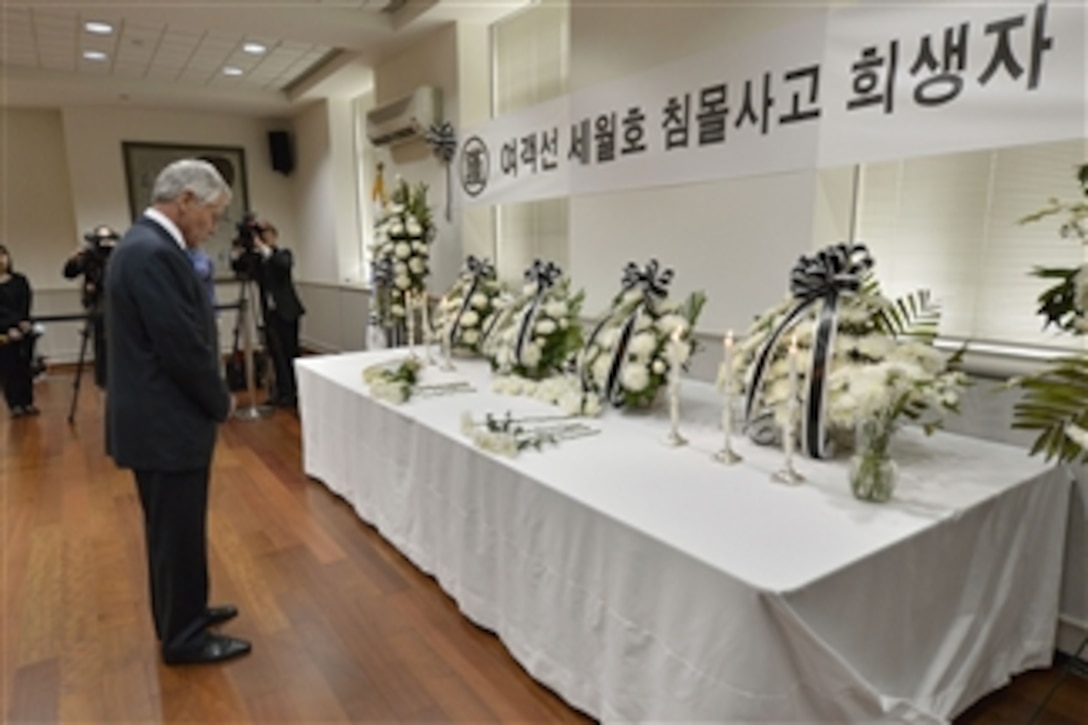 U.S. Defense Secretary Chuck Hagel paused for a moment of silence after laying a flower on a memorial table at the South Korean Embassy in Washington, D.C., May 10, 2014, in memory of the roughly 270 victims of the Korean ferry incident, April 16. Hagel also signed a condolence book.