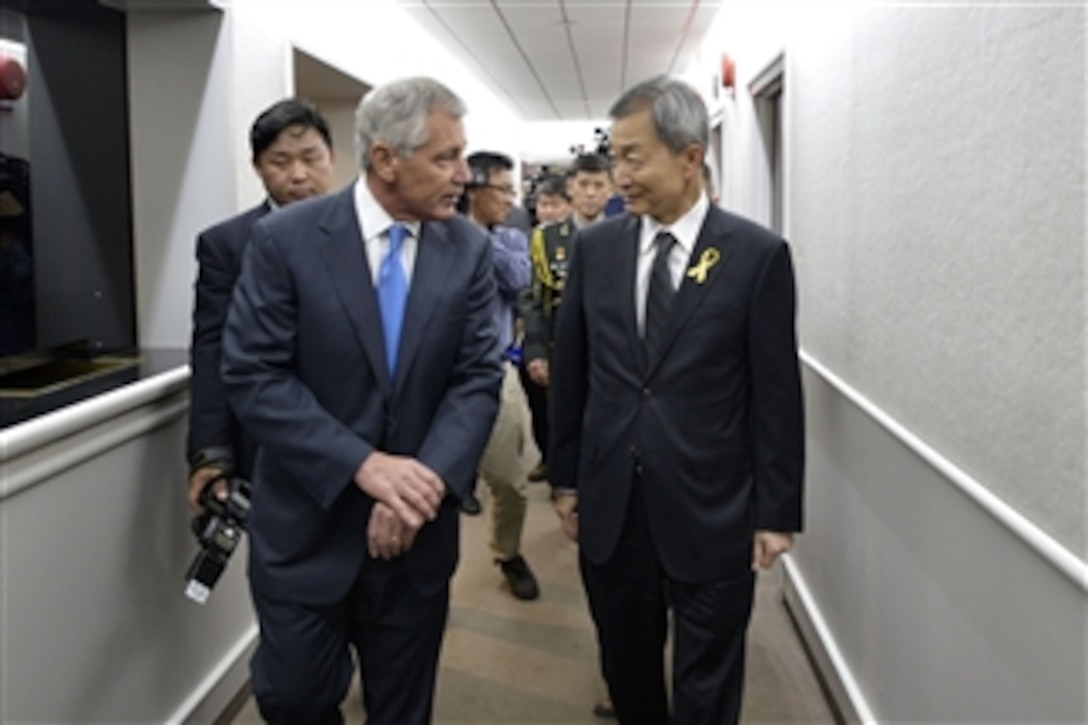 U.S. Defense Secretary Chuck Hagel is escorted by Ahn Ho-young, South Korean ambassador to the United States, as he visits the South Korean Embassy in Washington, D.C., May 10, 2014. Hagel later signed the condolence book in memory of the roughly 270 victims of Korean ferry incident, April 16. 