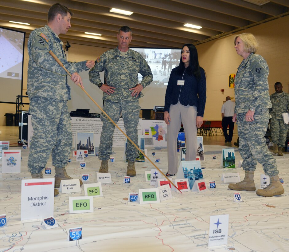 Lt. Col. John L. Hudson, U.S. Army Corps of Engineers Nashville District commander, (Left) discusses movements with Brigadier General Jeff Holmes, Assistant Adjutant General, Army Deputy Chief of Engineers, Army National Guard Affairs, Tennessee Army National Guard, Ms. Karen Durham-Aguilera, U.S. Army Corps of Engineers director of Contingency Operations and Homeland Security and Brigadier General Margaret W. Burcham, Commander and Division Engineer of the Great Lakes and Ohio River Division when emergency management officials moved pictures and signs, much like game pieces on a large board game, on a 24-by-24 foot floor map of the New Madrid seismic zone May 7-9, 2014 at the National Guard Armory in Jackson, Tenn.  The drill simulated an emergency response in the event of a major earthquake.  Emergency management officials moved pictures and signs, much like game pieces on a large board game, on a 24-by-24 foot floor map of the New Madrid seismic zone May 7-9, 2014 at the National Guard Armory in Jackson, Tenn.  The exercise simulated an emergency response in the event of a major earthquake. (USACE photo by Mark Rankin)