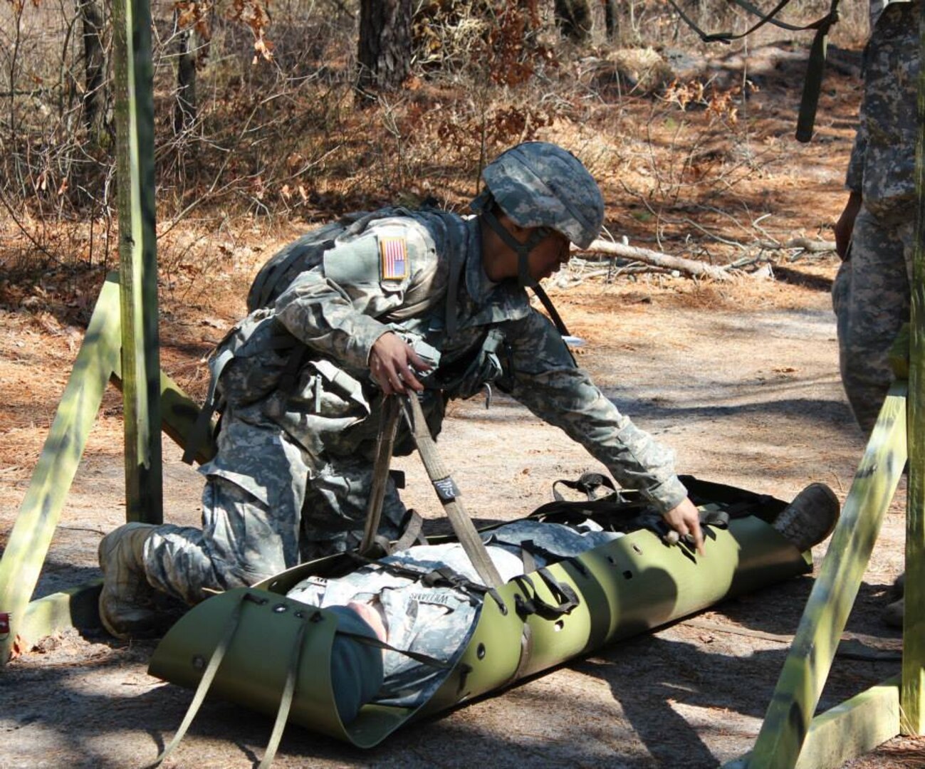 Badge candidates practice securing soldiers to a combat stretcher, known as a litter, during badge qualification. 