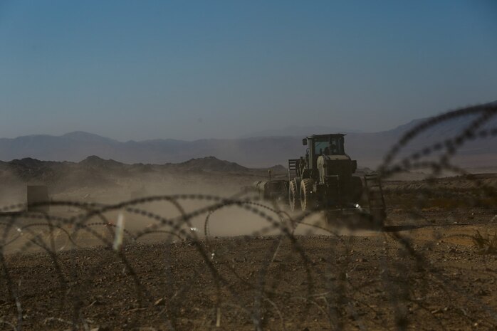 A Marine convoy with Headquarters Battalion, 1st Marine Division, leaves friendly lines with a convoy at the division entry control point during Exercise Desert Scimitar at Marine Corps Air Ground Combat Center Twentynine Palms, Calif., May 10, 2014. The training allows the division to test and refine its command and control capabilities by acting as the headquarters element of I Marine Expeditionary Force. The tough live-fire training that accompanies the exercise allows 1st Marine Division to meet possible real-world operational demands. (U.S. Marine Corps photograph by Sgt. Timothy Lenzo/RELEASED)