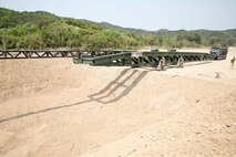 U.S. Marines push a medium girder bridge over a gap using a 7-ton truck April 25 during Korean Marine Exchange Program 14-6 in Pohang, Republic of Korea. An MGB is a lightweight, man-portable bridge, which can be assembled without using heavy equipment, and is capable of supporting troops and tactical vehicle. 