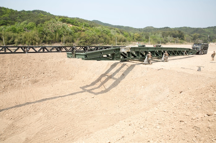 U.S. Marines push a medium girder bridge over a gap using a 7-ton truck April 25 during Korean Marine Exchange Program 14-6 in Pohang, Republic of Korea. An MGB is a lightweight, man-portable bridge, which can be assembled without using heavy equipment, and is capable of supporting troops and tactical vehicle. 