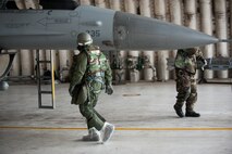 Lt. Col. Henry Jeffress, 80th Fighter Squadron director of operations, inspects an F-16 during exercise Beverly Bulldog 14-2 at Kunsan Air Base, Republic of Korea, May 9, 2014. This exercise tested the Wolf Pack's ability to perform its mission while under threat of chemical attack. (U.S. Air Force photo by Staff Sgt. Clayton Lenhardt/Released)