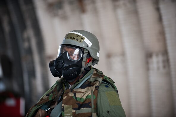 Lt. Col. Henry Jeffress, 80th Fighter Squadron director of operations, watches as a crew chief performs an inspection on an F-16 during exercise Beverly Bulldog 14-2 at Kunsan Air Base, Republic of Korea, May 9, 2014. This exercise tested the Wolf Pack's ability to perform its mission while under threat of chemical attack. (U.S. Air Force photo by Staff Sgt. Clayton Lenhardt/Released)