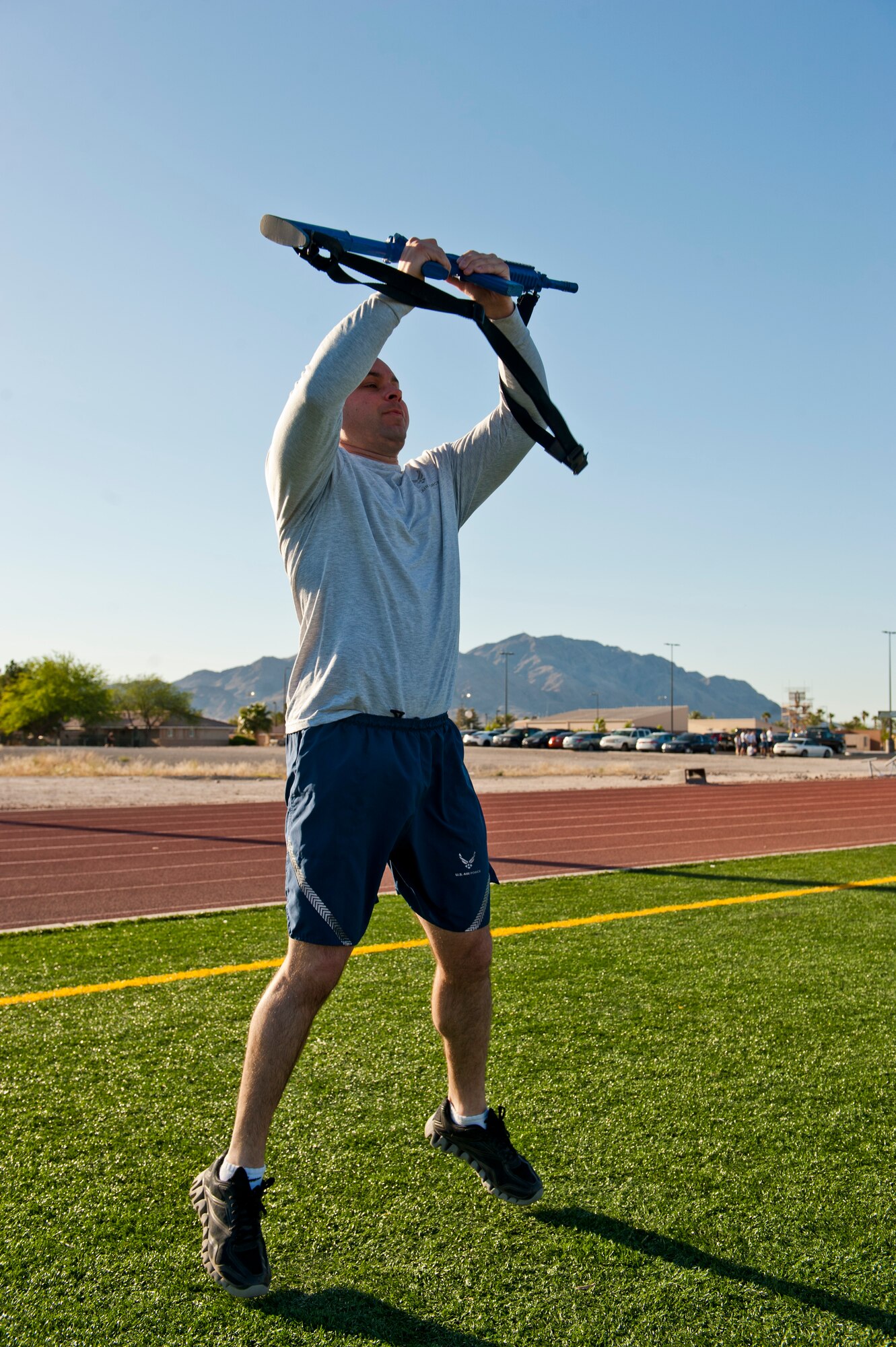 U.S. Air Force Tech. Sgt. Brady Warren, 99th Security Forces Squadron criminal intelligence analyst, raises a training weapon over his head as part of an exercise during a Warrior Trained Fitness session at the Warrior Fitness Center May 13, 2014, at Nellis Air Force Base, Nev. The training weapon was being used in an exercise in honor of Police Week. (U.S. Air Force photo by Airman 1st Class Thomas Spangler)