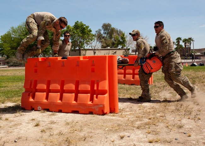 Members of the 58th Rescue Squadron’s “team 2” transfer a mannequin over barriers during the 99th Medical Group’s Life of a Warrior Challenge May 9, 2014 at Nellis Air Force Base, Nev. Participants were scored on the time it took them to complete eight stages while transporting a bag of medical supplies and a mannequin on a litter between each stage. (U.S. Air Force photo illustration by Senior Airman Timothy Young)