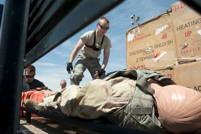 Airman 1st Class Jake Carter, 99th Air Base Wing Public Affairs photojournalist, hands off boxes of simulated human blood from the bed of a truck during the 99th Medical Group’s Life of a Warrior Challenge May 9, 2014 at Nellis Air Force Base, Nev. Teams completed eight medical based objectives during the event, the team with the best time at the end of the course was named the winners. (U.S. Air Force photo by Senior Airman Timothy Young)