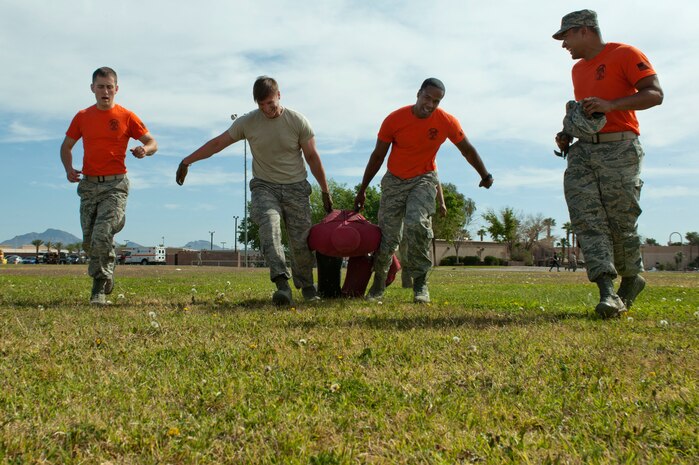 The Combat Search and Rescue Combined Test Force team carries a training mannequin during the 99th Medical Group’s Life of a Warrior Challenge May 9, 2014 at Nellis Air Force Base, Nev. The mannequin weight was equivalent to carrying a full grown human. (U.S. Air Force photo by Senior Airman Timothy Young)