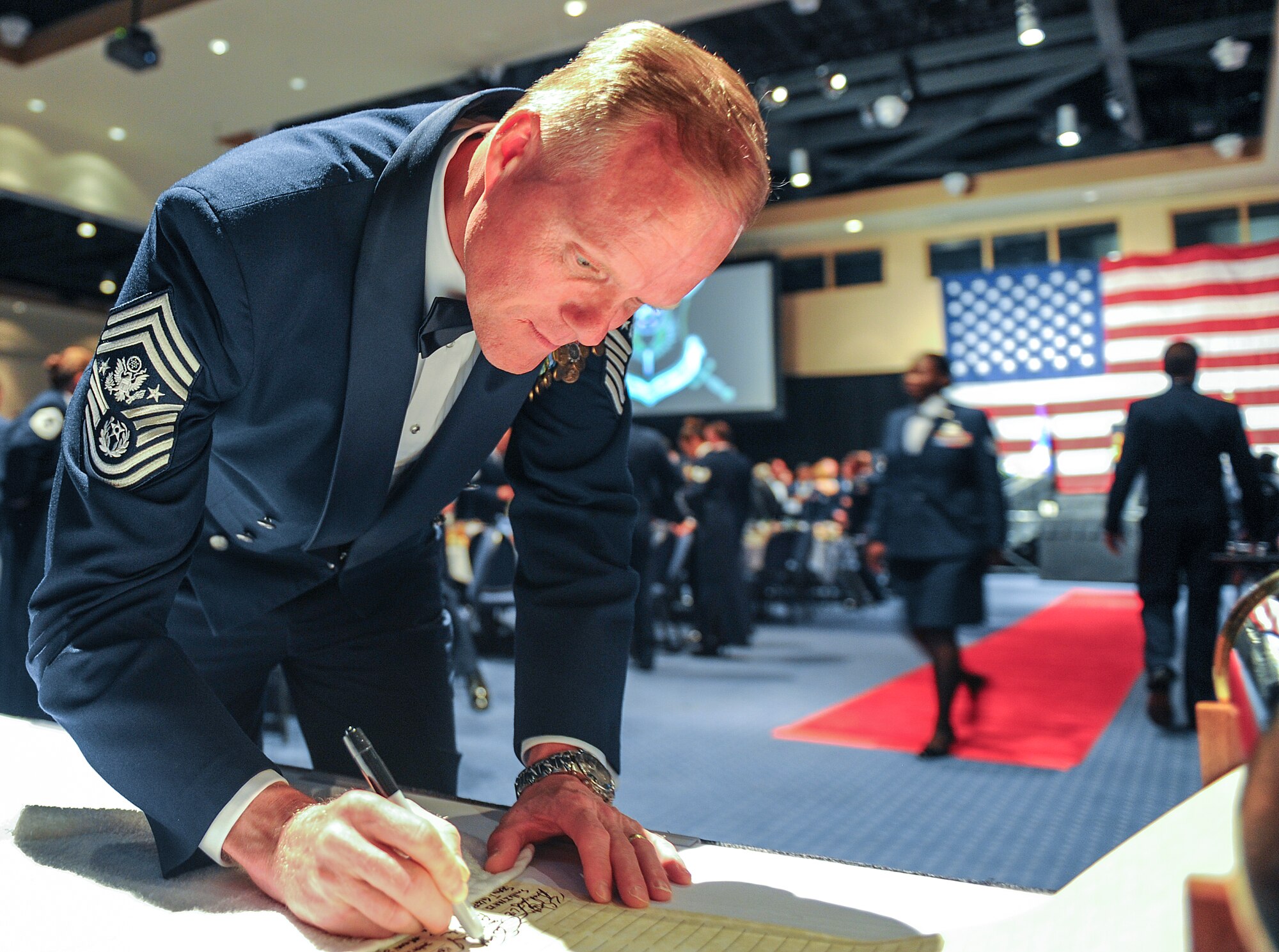 Chief Master Sgt. of the Air Force James Cody signs a scroll at the Emerald Coast Convention Center in Fort Walton Beach, Fla., May 9, 2014. More than 500 enlisted Airmen honored Lt. Gen. Eric Fiel, Air Force Special Operations Command commander, at his Order of the Sword ceremony. (U.S. Air Force photo/Airman 1st Class Jeff Parkinson)