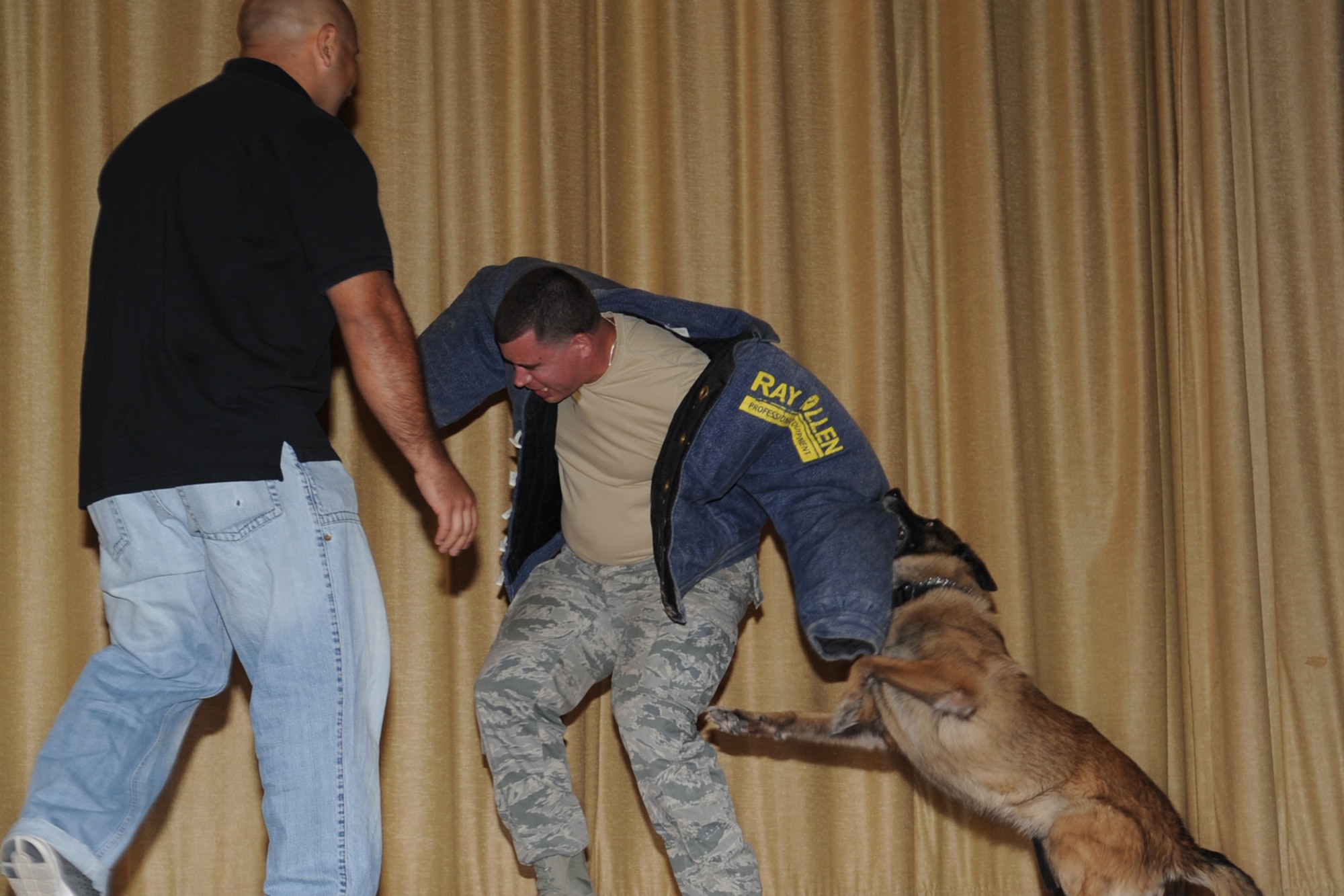 GOODFELLOW AIR FORCE BASE, Texas -- Rocky, 17th Security Forces Squadron military working dog, bites Staff Sgt. Jonathan R. Halcomb, 17th SFS MWD handler, during the last bite portion of Rocky’s retirement ceremony at the base theater here May 9. The last bite is a tribute to the retiring dog signifying his mission is complete. (U.S. Air Force photo/ Staff Sgt. Laura R. McFarlane)