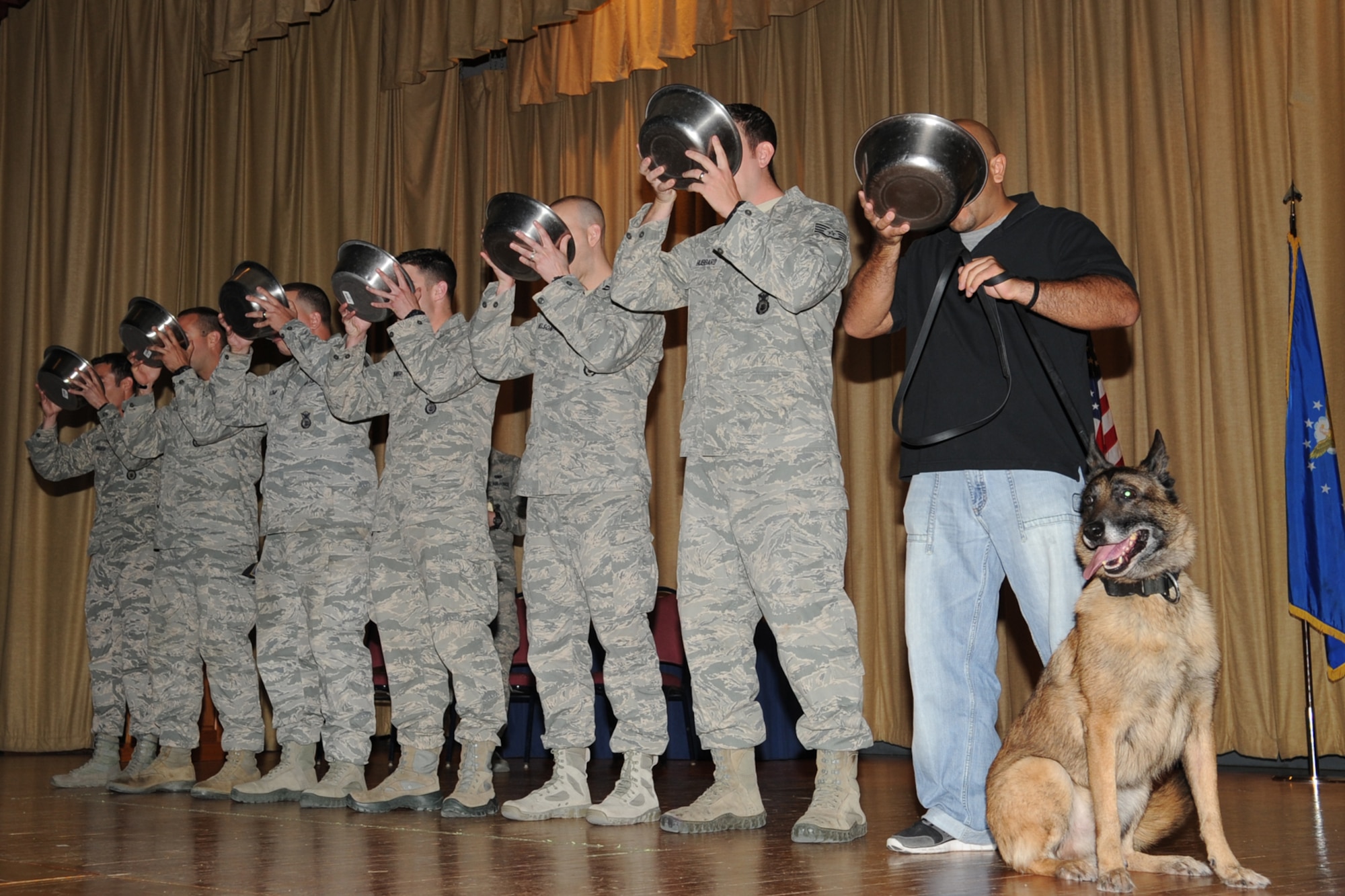 GOODFELLOW AIR FORCE BASE, Texas-- Members of the 17th Security Forces Squadron and Ronnie G. Garcia, Department of Homeland Security Explosive Detection K9 handler, drink from water bowls for the ultimate toast during Rocky’s, 17th SFS military working dog, retirement ceremony at the base theater here May 9. The 17th SFS honored Rocky with a toast, which dates back to Russian Czars and King George III of England. (U.S. Air Force photo/ Staff Sgt. Laura R. McFarlane)
