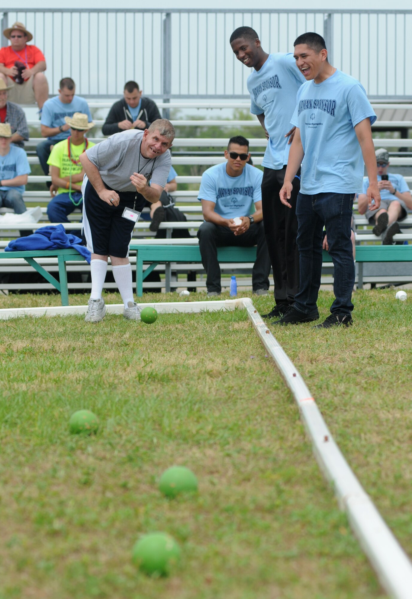 John McMillian, athlete, tosses a bocce ball while being supported by his Airmen sponsors, Airmen Basic Darnell Dixon and Paulo Duarte, 336th Training Squadron, during the Special Olympics Mississippi Summer Games May 10, 2014, near  the triangle track, at Keesler Air Force Base, Miss.  More than 900 athletes and 3,000 volunteers worked together to hold competitions throughout the day.  This is the 28th year Keesler has hosted the state Special Olympics.  (U.S. Air Force photo by Kemberly Groue)