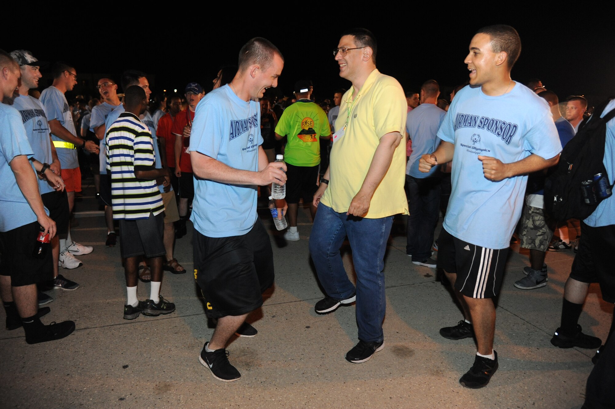 Michael Terry, athlete, and his Airmen sponsors, display their dancing skills at the victory dance during the Special Olympics Mississippi Summer Games May 10, 2014, behind the Levitow Training Support Facility, at Keesler Air Force Base, Miss.  More than 900 athletes and 3,000 volunteers worked together to hold competitions throughout the day.  This is the 28th year Keesler has hosted the state Special Olympics.  (U.S. Air Force photo by Kemberly Groue)