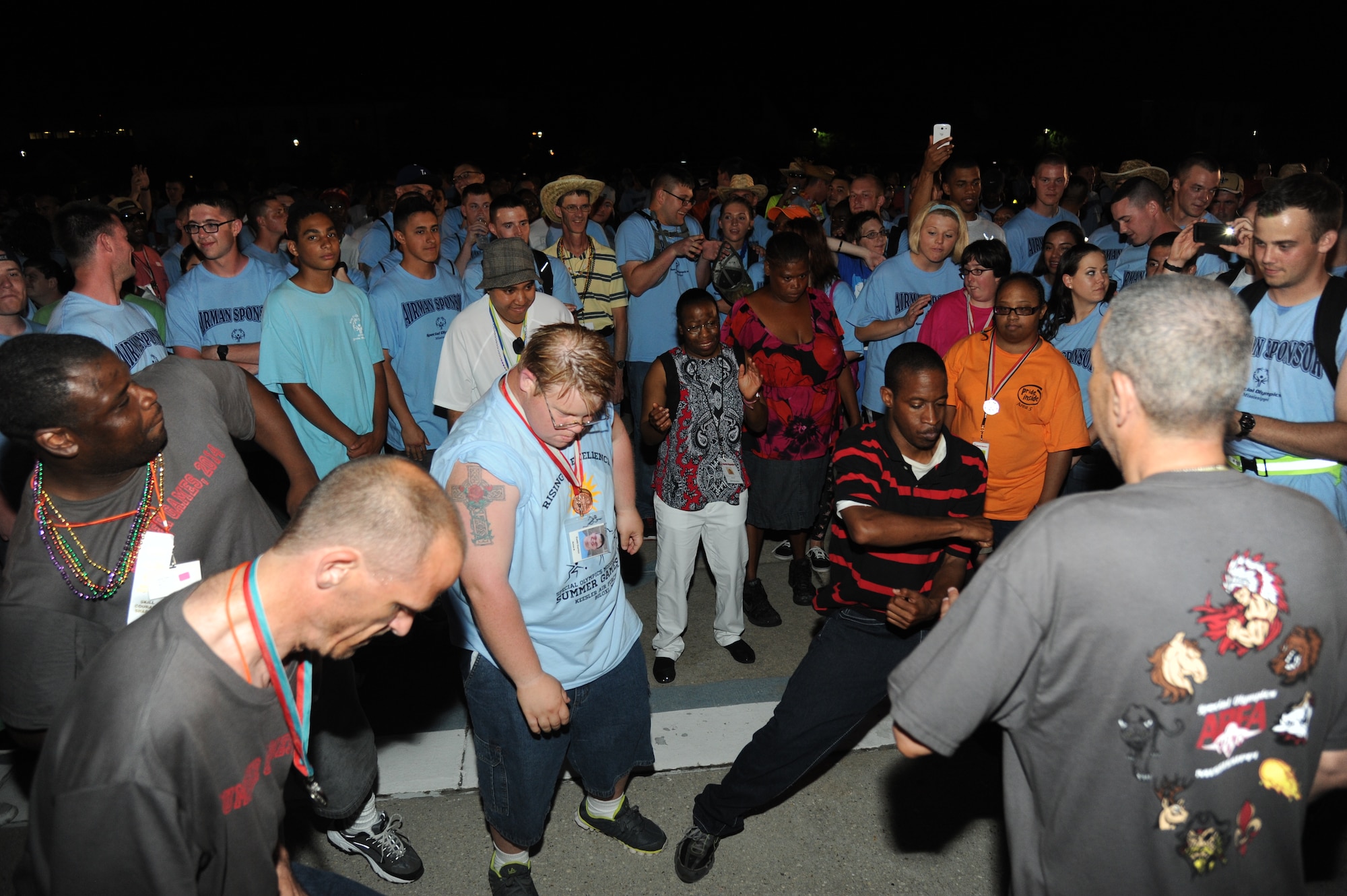 Athletes display their dancing skills with Airmen sponsors and fellow athletes at the Special Olympics Mississippi Summer Games victory dance May 10, 2014, behind the Levitow Training Support Facility, at Keesler Air Force Base, Miss.  More than 900 athletes and 3,000 volunteers worked together to hold competitions throughout the day.  This is the 28th year Keesler has hosted the state Special Olympics.  (U.S. Air Force photo by Kemberly Groue)