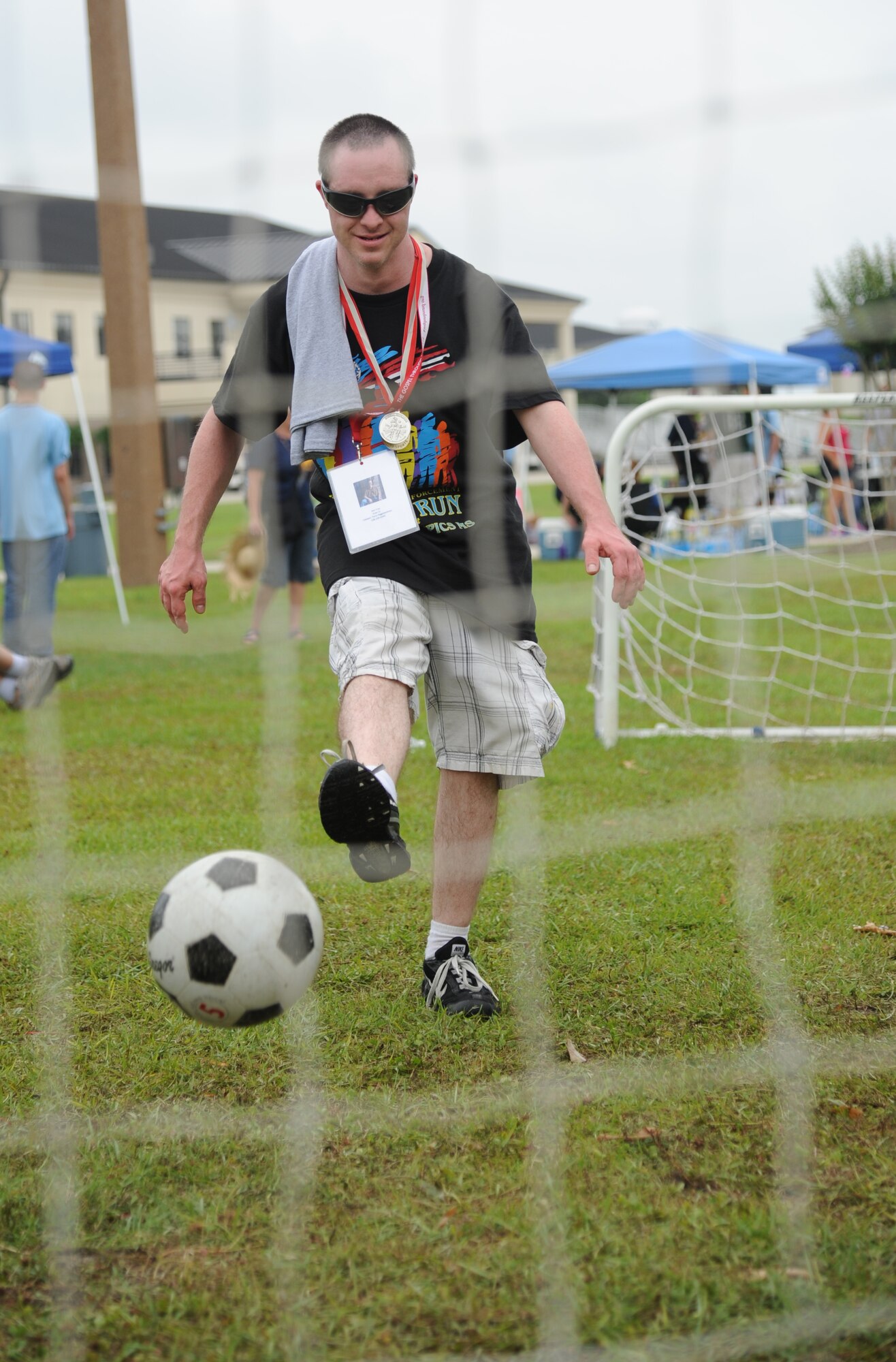 Ken Frye, athlete, kicks a soccer ball towards a net at Olympic Village during the Special Olympics Mississippi Summer Games May 10, 2014, at the student parade grounds, at Keesler Air Force Base, Miss.  More than 900 athletes and 3,000 volunteers worked together to hold competitions throughout the day.  This is the 28th year Keesler has hosted the state Special Olympics.  (U.S. Air Force photo by Kemberly Groue)