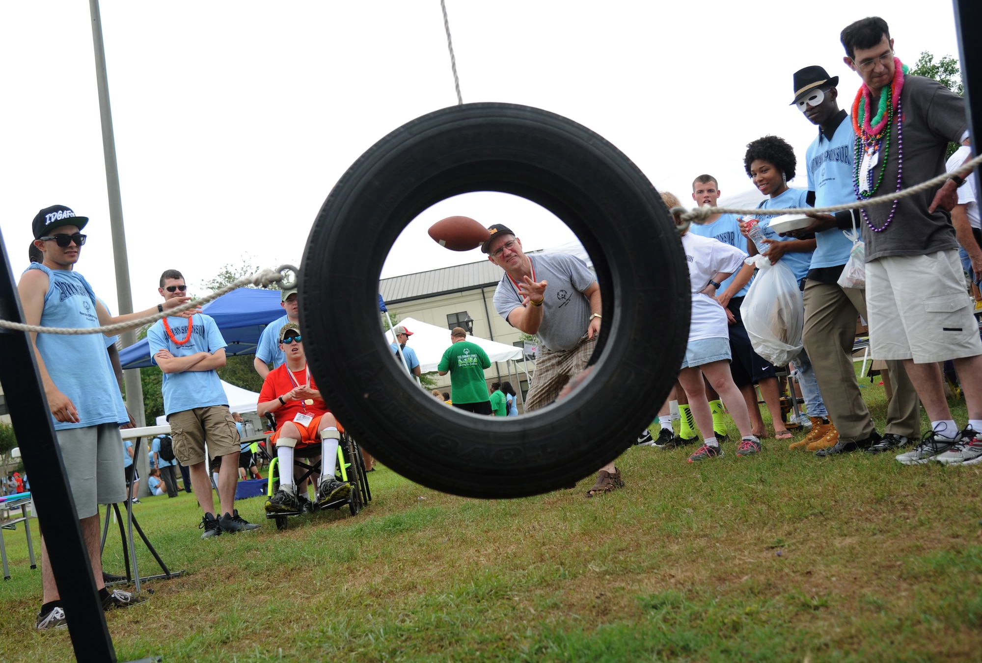 Roy Roberts, athlete, throws a football through a tire at the Olympic Village during the Special Olympics Mississippi Summer Games May 10, 2014, at the student parade grounds, at Keesler Air Force Base, Miss.  More than 900 athletes and 3,000 volunteers worked together to hold competitions throughout the day.  This is the 28th year Keesler has hosted the state Special Olympics.  (U.S. Air Force photo by Kemberly Groue)