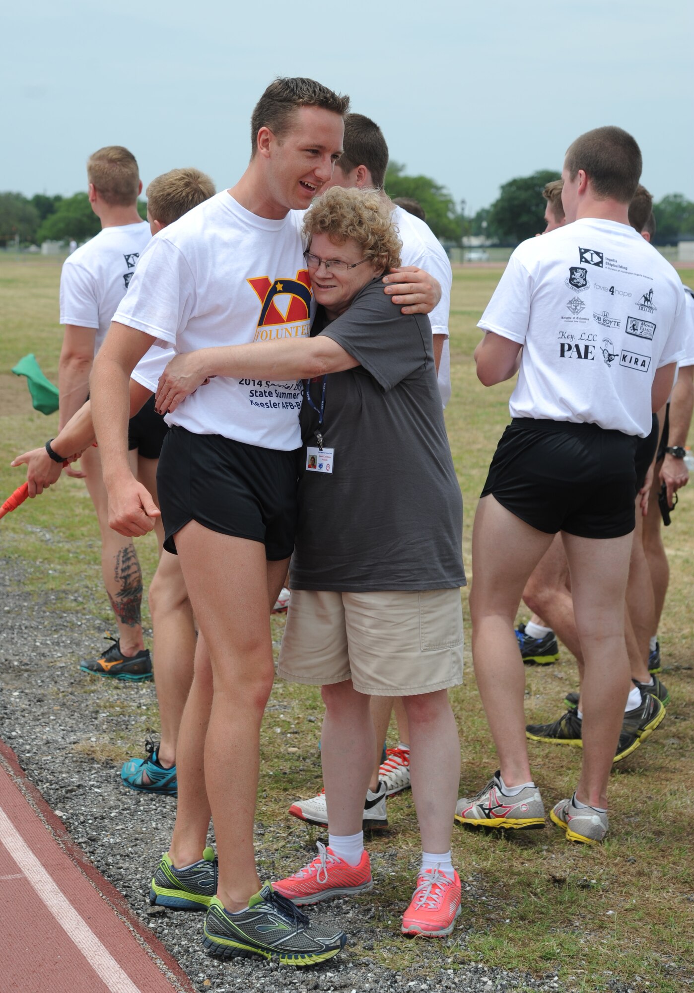 Airman 1st Class David Wallis, 334th Training Squadron combat controller, hugs Janet Carrithers, athlete, after she completed the 400-meter walk during the Special Olympics Mississippi Summer Games May 10, 2014, at the triangle track, at Keesler Air Force Base, Miss.  More than 900 athletes and 3,000 volunteers worked together to hold competitions throughout the day. This is the 28th year Keesler has hosted the state Special Olympics.  (U.S. Air Force photo by Kemberly Groue)