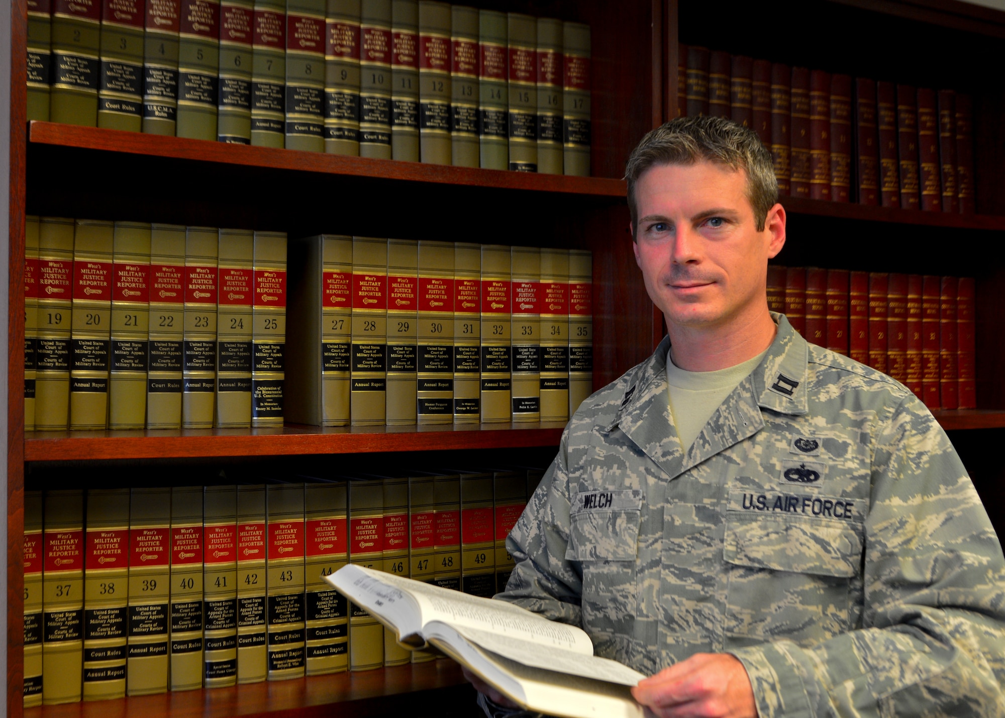 Capt. Scott Welch, 436th Airlift Wing area defense counsel, holds a law book May 13, 2014, at the ADC office on Dover Air Force Base, Del. Welch provides defense representation for Airmen on Dover AFB and surrounding installations. (U.S. Air Force photo/Airman 1st Class William Johnson)