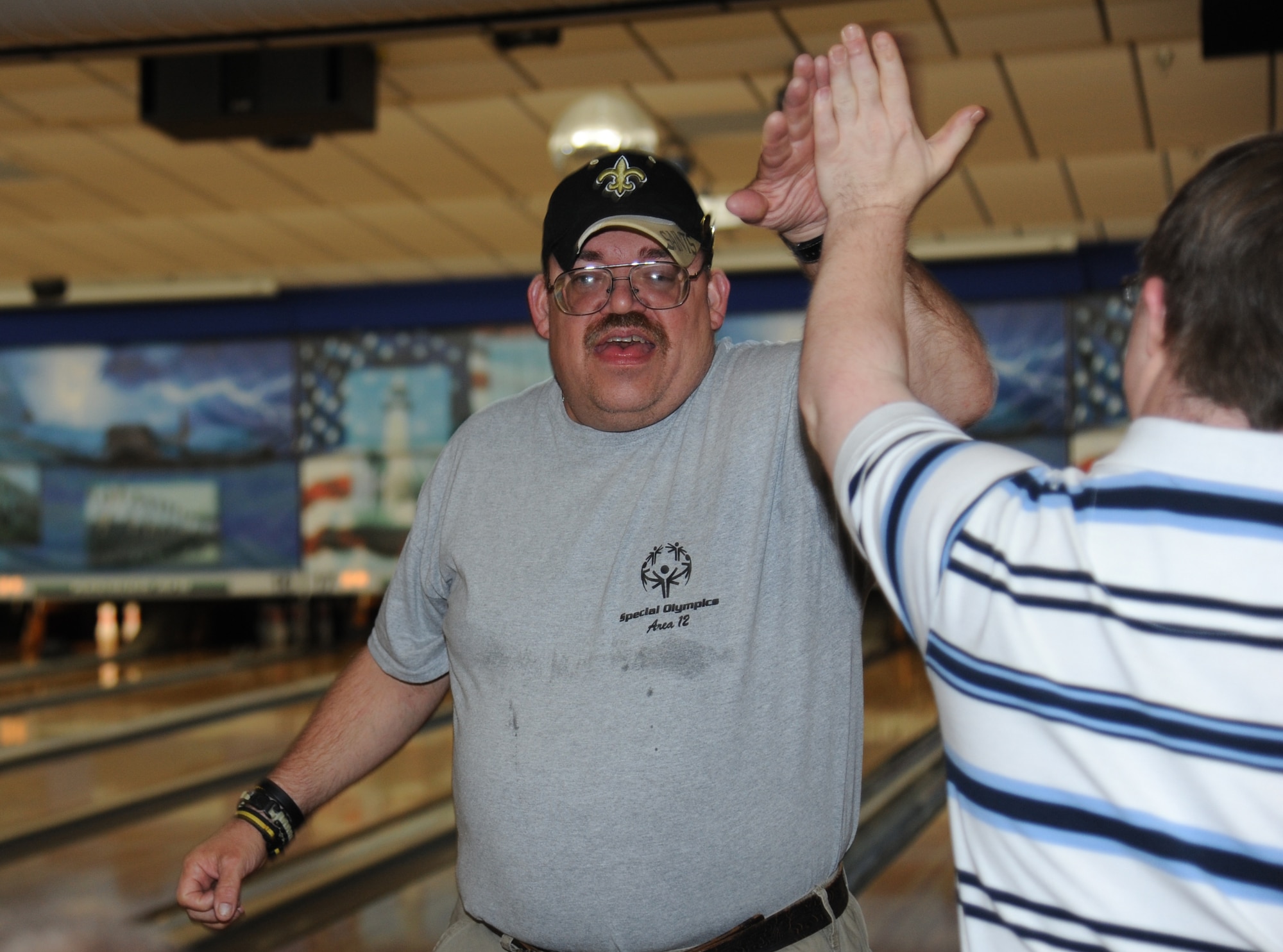 Dale Seymour, athlete, high-fives a fellow athlete after bowling a strike during the Special Olympics Mississippi Summer Games May 10, 2014, at Gaude Lanes, at Keesler Air Force Base, Miss.  More than 900 athletes and 3,000 volunteers worked together to hold competitions throughout the day.  This is the 28th year Keesler has hosted the state Special Olympics. (U.S. Air Force photo by Kemberly Groue)