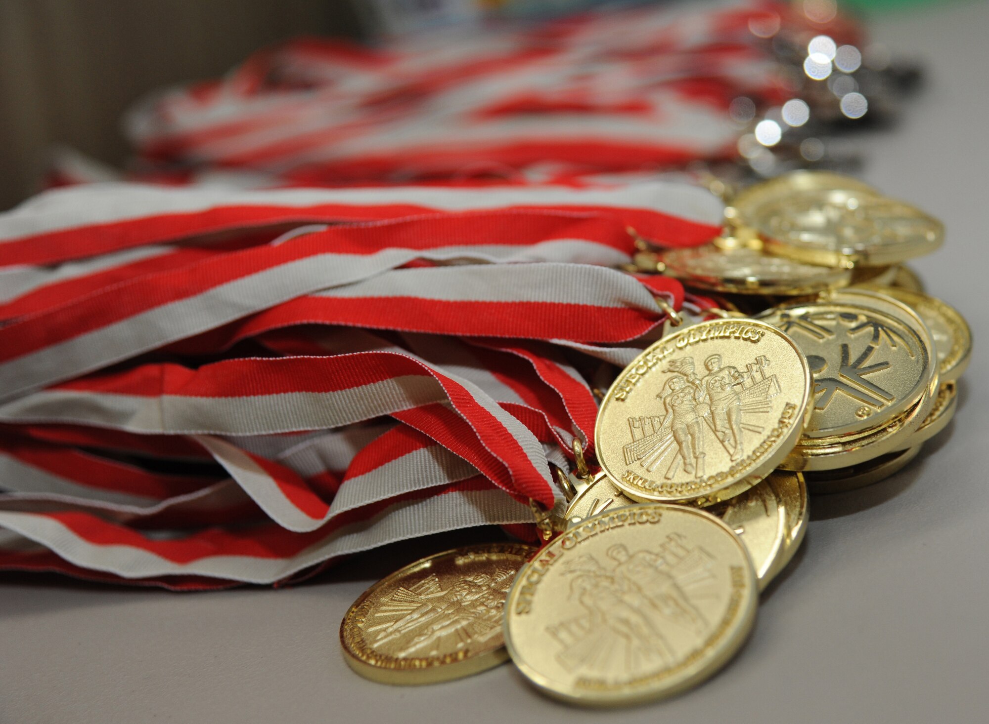 Gold medals sit on display to be awarded to athletes during the Special Olympics Mississippi Summer Games May 10, 2014, at Gaude Lanes, at Keesler Air Force Base, Miss.  More than 900 athletes and 3,000 volunteers worked together to hold competitions throughout the day.  This is the 28th year Keesler has hosted the state Special Olympics.  (U.S. Air Force photo by Kemberly Groue)