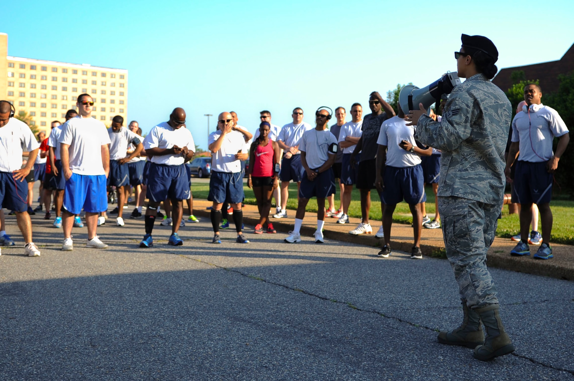 U.S. Air Force Senior Airman Kristin Delgado, 633rd Security Forces Squadron unit scheduler, briefs runners before the National Police Week 5K run at Langley Air Force Base, Va., May 13, 2014. Joint Base Langley-Eustis officials will hold more events throughout the week, including a motorcycle ride, K9 demonstration and weapons display to honor law enforcement personnel. (U.S. Air Force photo by Senior Airman Austin Harvill/Released) (photo cropped, contrasted, color corrected, dodged, burned and sharpened for effect)