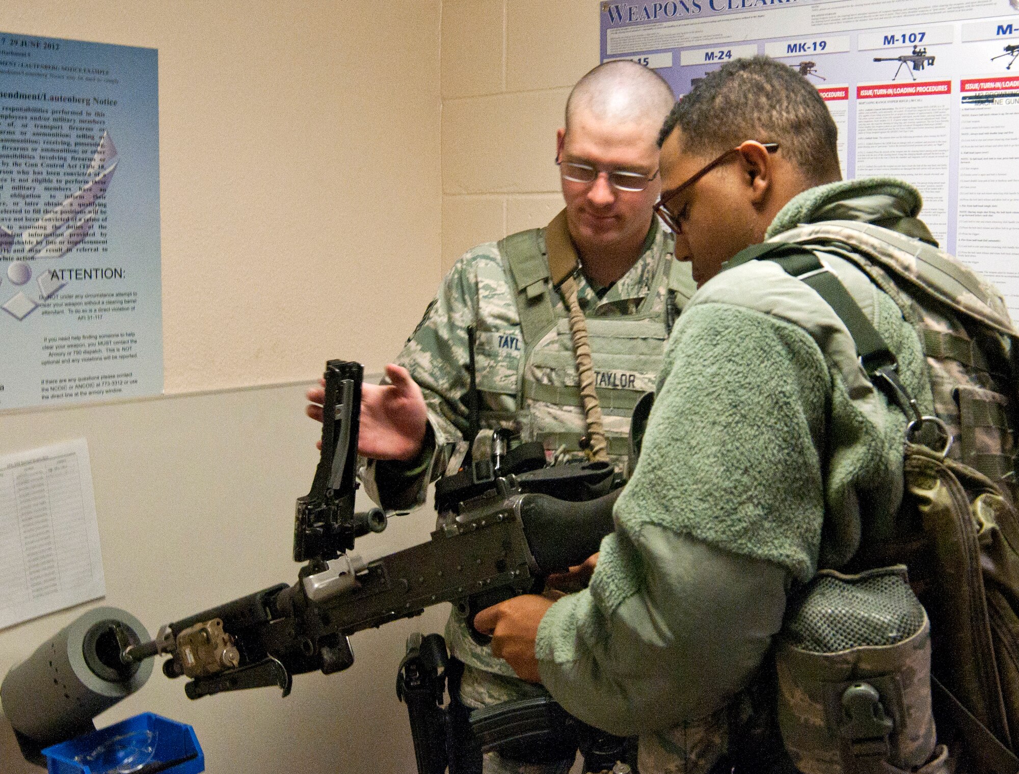 Staff Sgt. Patrick Taylor and Airman 1st Class Tyler Blevins, both in the 90th Security Forces Squadron, clear an M-240B machine gun issued to Blevins in Building 34 before starting his shift May 13, 2014. Clearing weapons is a procedure to check for unexpected ammunition to ensure weapon safety and ammunition accountability. (U.S. Air Force photo by Airman 1st Class Jason Wiese)