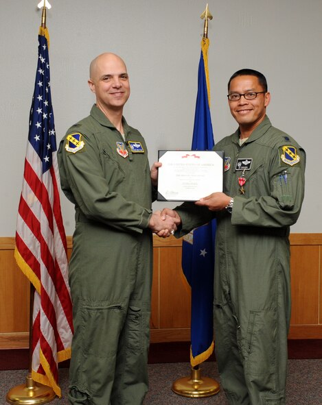 U.S. Air Force Col. Michael Bob Starr, left, 7th Bomb Wing commander, presents Lt. Col. Jose Sumangil, 9th Bomb Squadron commander, with a certificate for the Bronze Star Medal May 12, 2014, at Dyess Air Force Base, Texas.  Sumangil credits his bronze star to the hard work of the Airmen of the 9th Expeditionary Bomb Squadron, who made it possible to accomplish the mission. (U.S. Air Force photo by Airman 1st Class Autumn Velez/Released) 