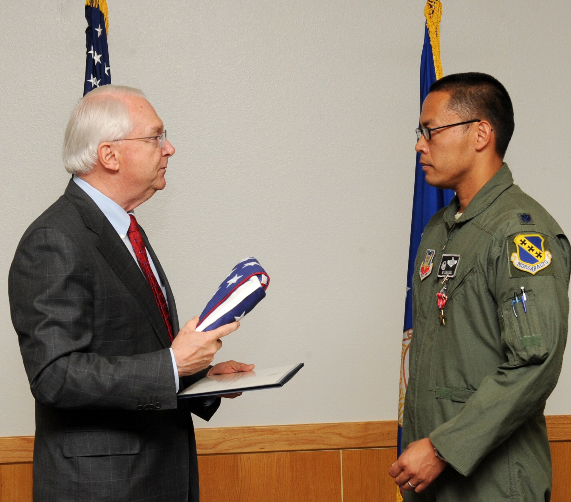 U.S. Rep. Randy Neugebauer presents U.S. Air Force Lt. Col. Jose Sumangil, 9th Bomb Squadron commander, with an American flag during Sumangil’s Bronze Star Medal presentation May 13, 2014, at Dyess Air Force Base, Texas. In honor of Sumangil’s accomplishments, Neugebauer presented a flag which was flown over the United States Capitol building. (U.S. Air Force photo by Airman 1st Class Autumn Velez/Released)