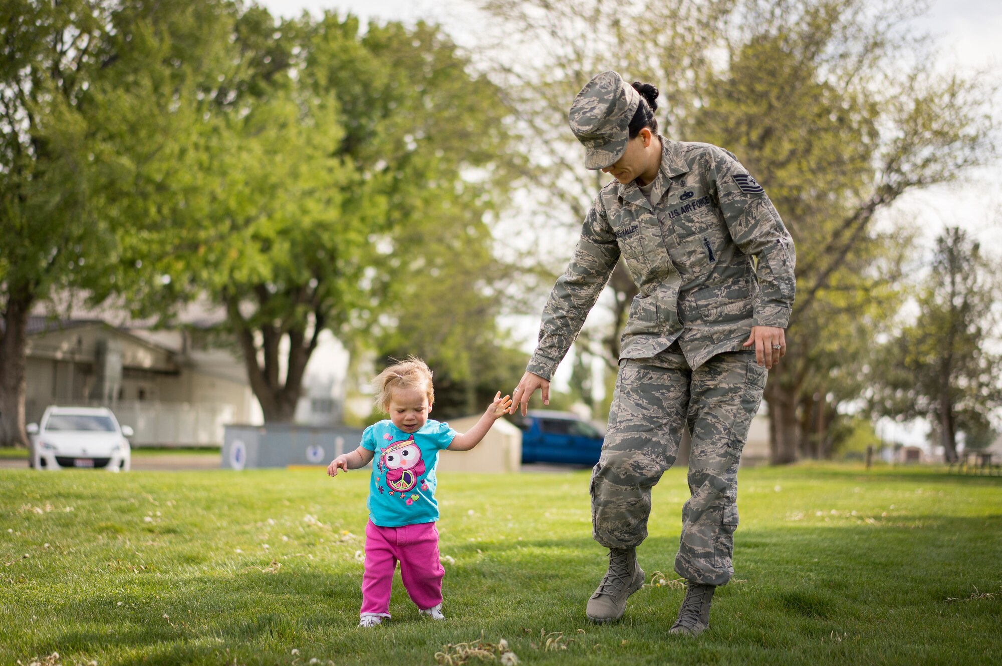 Oleksandra Valley, daughter of Tech. Sgt. Jamie Meadows-Valley from the 366th Aerospace Medicine Squadron, cautiously lets go of her mother's hand while trying to walk at Mountain Home Air Force Base, Idaho, on May 6, 2014. Since being adopted from a Ukrainian orphanage, Oleksandra has thrived, learning to walk and feed herself. (U.S. Air Force photo/Tech. Sgt. Samuel Morse)