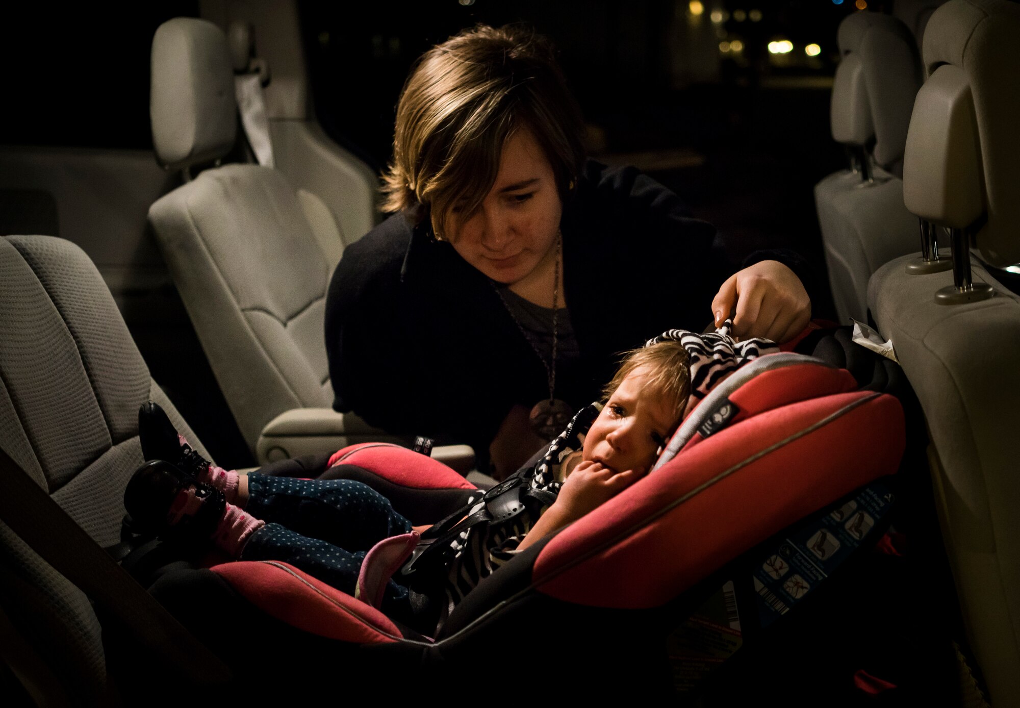 Jewel Valley comforts her sister, Oleksandra, at a friend's house in Boise, Idaho. Just like many toddlers, Oleksandra still doesn't like riding in her car seat. (U.S. Air Force photo/Tech. Sgt. Samuel Morse)
